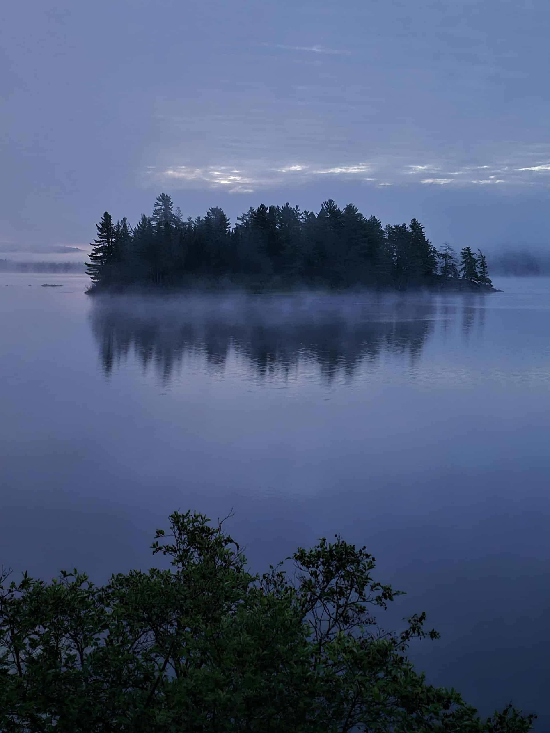 A misty island on lake of two rivers, at sunrise.