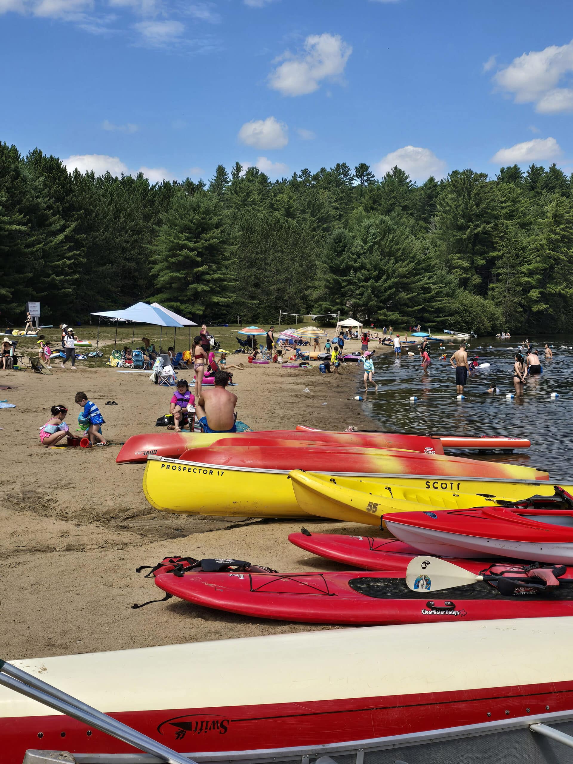 A crowded sandy beach on Lake of Two Rivers,