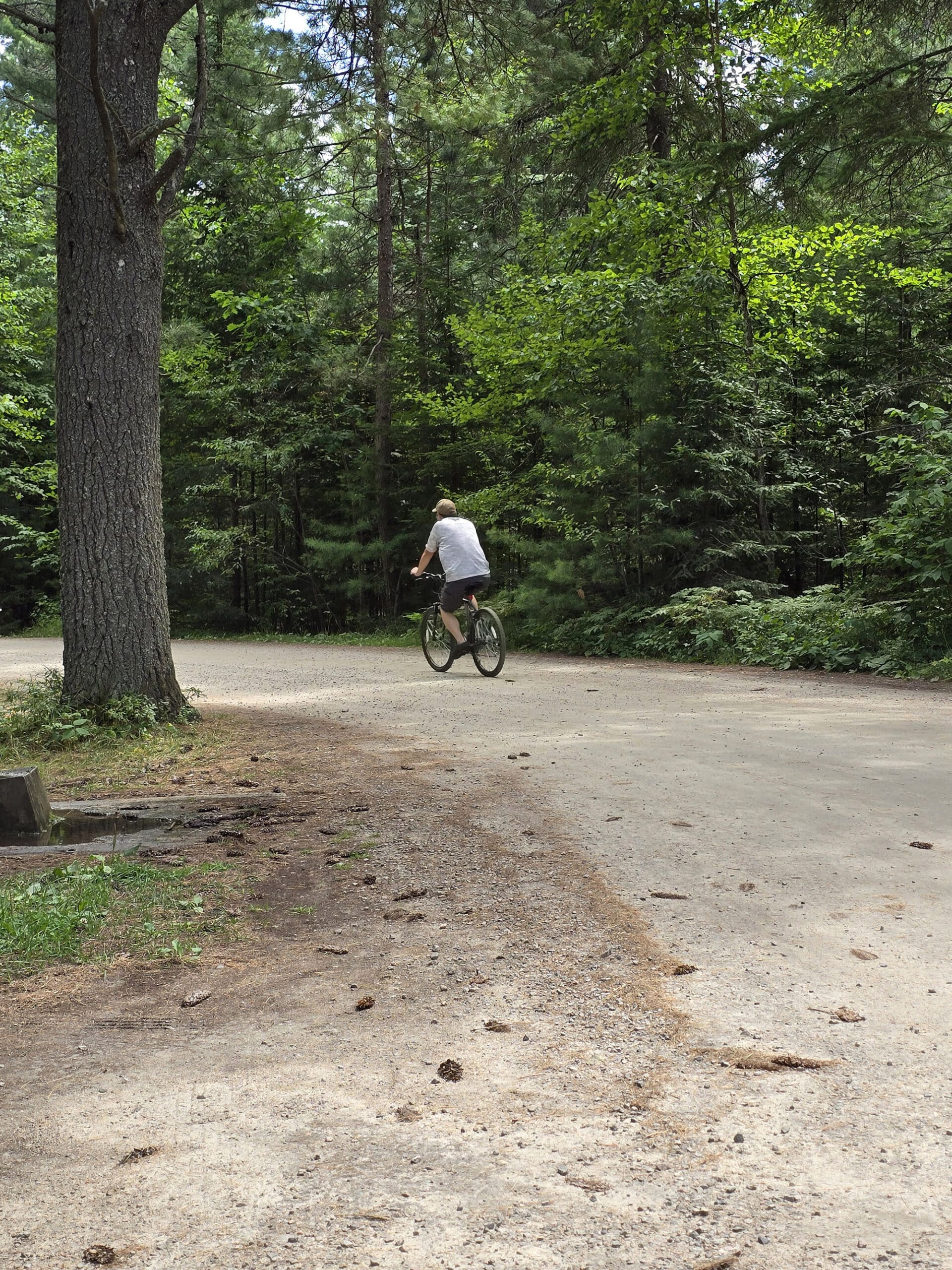 A man cycling away ona  campground road.