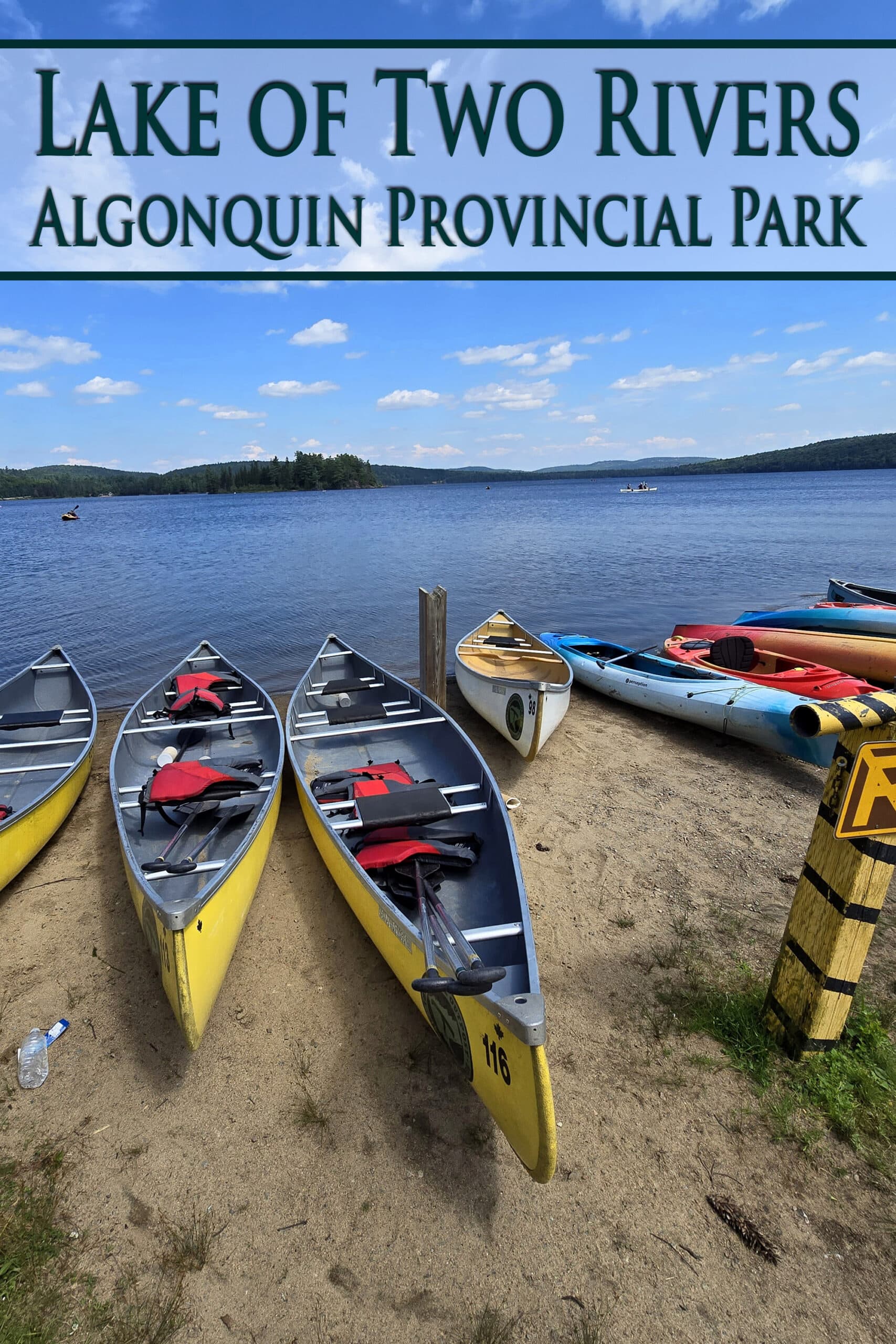 Several brightly coloured canoes on the beach at lake of two rivers.