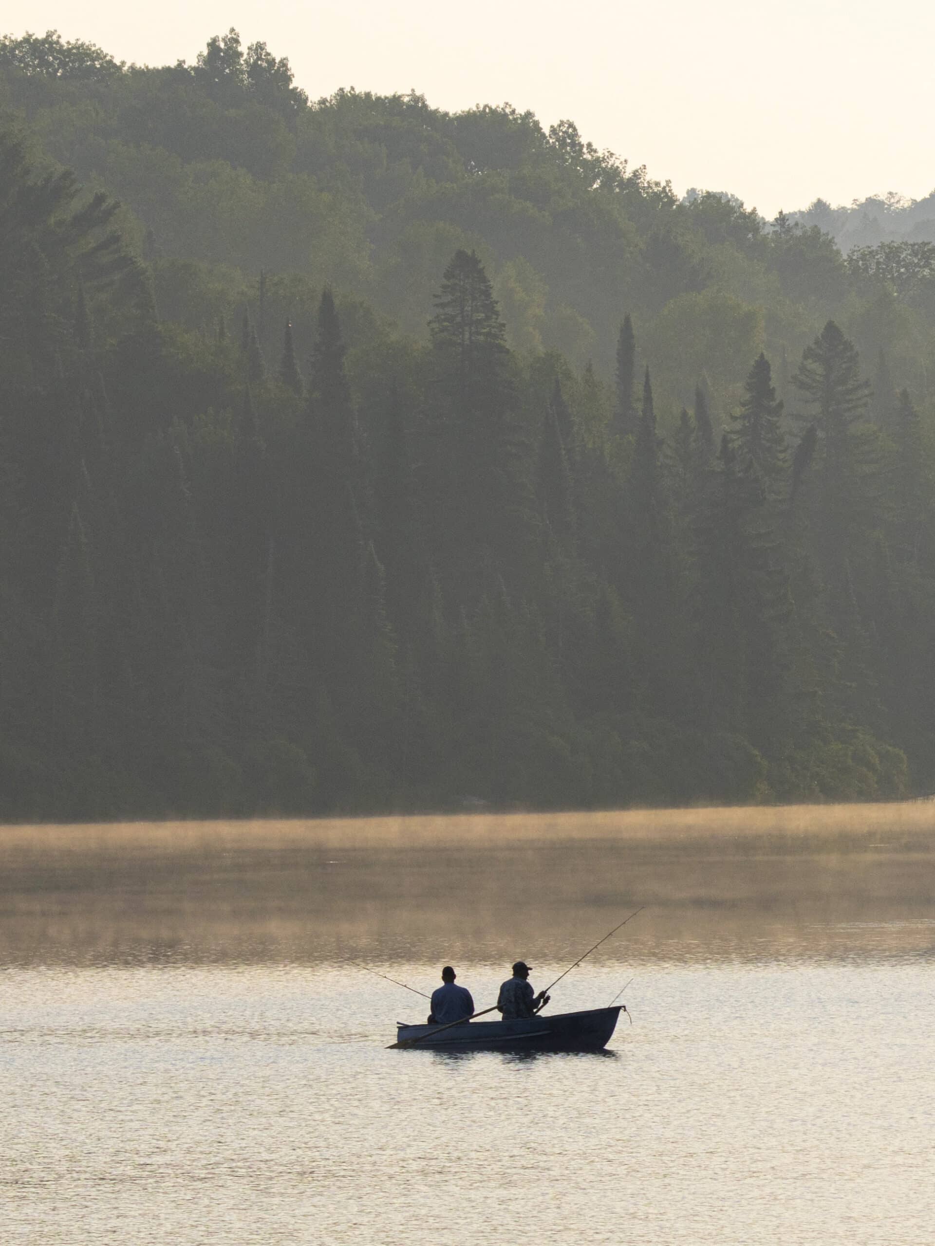 2 people fishing in a canoe.