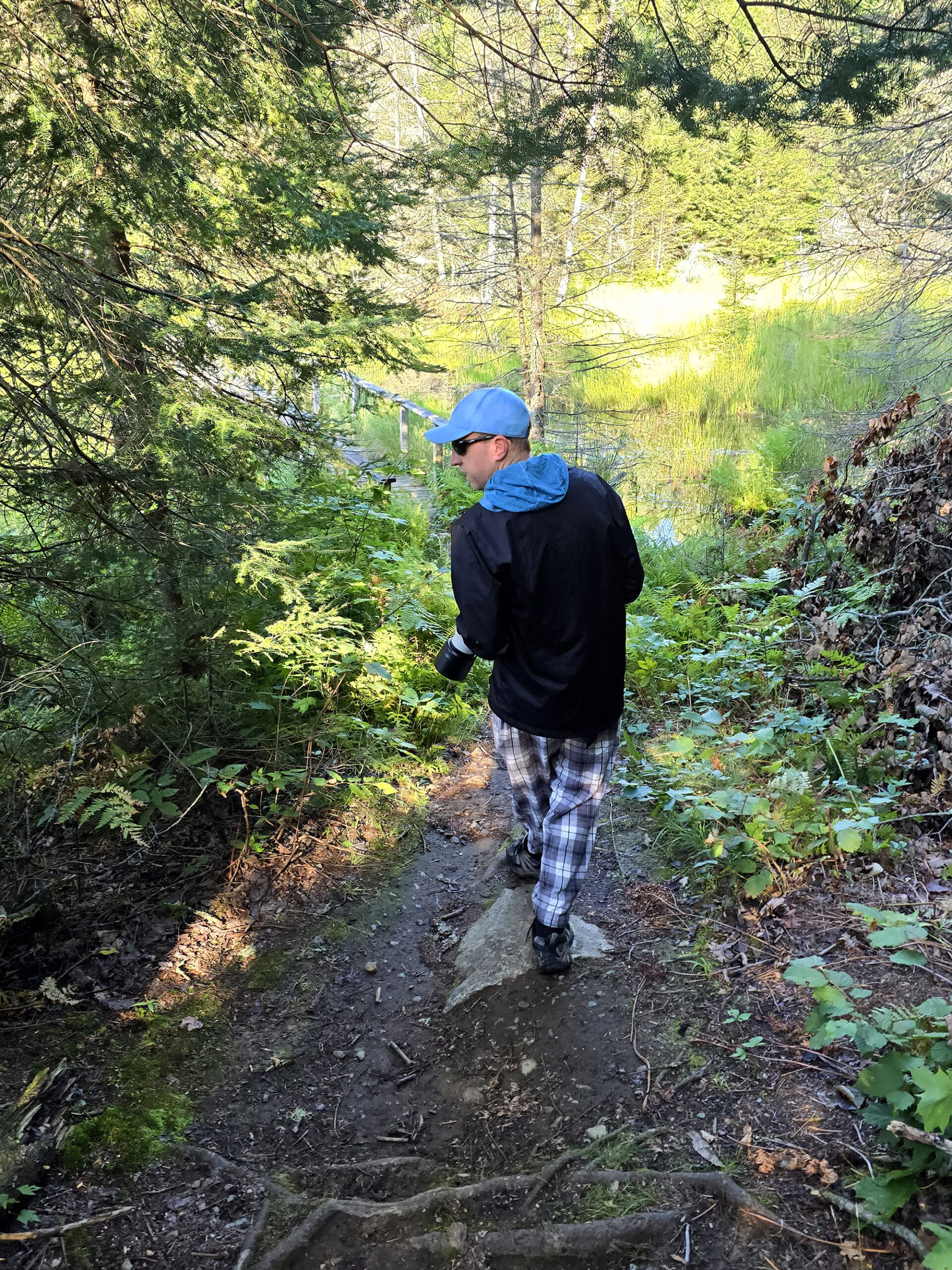 The author’s husband with a large camera, birding in the woods at Mikisew Provincial Park.