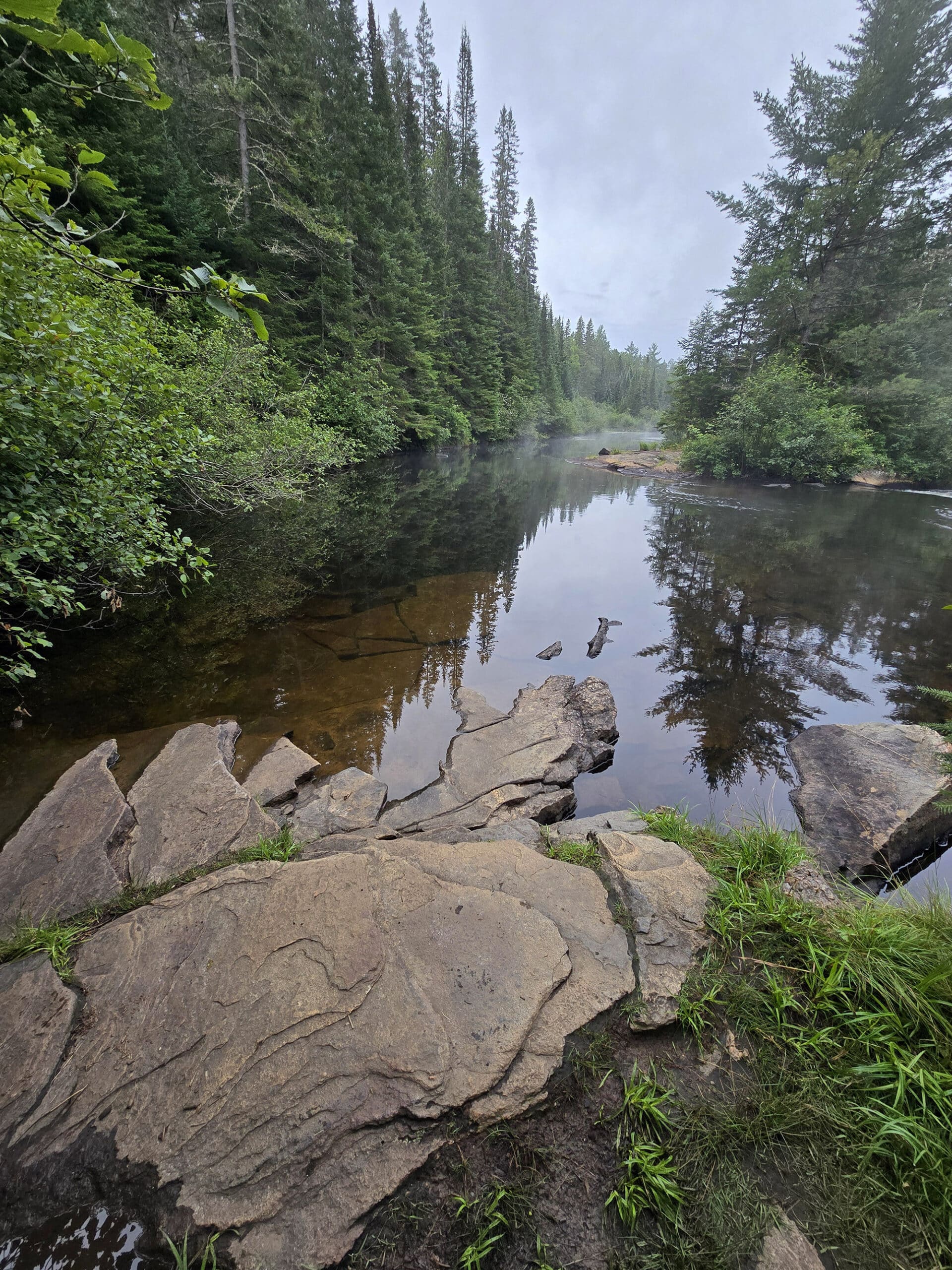 Rocks and still water at the top of a waterfall.