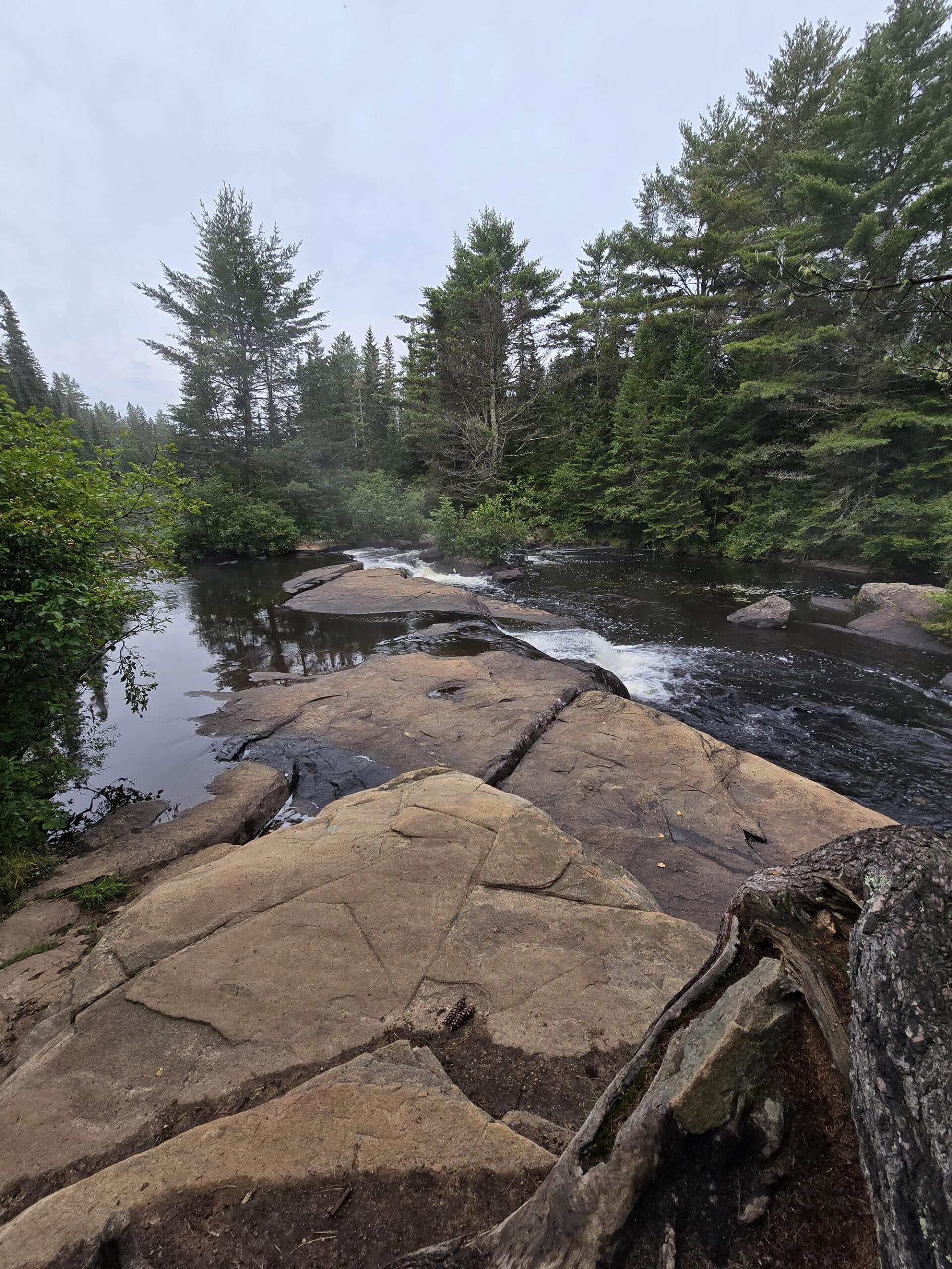 Rocks and still water at the top of a waterfall.