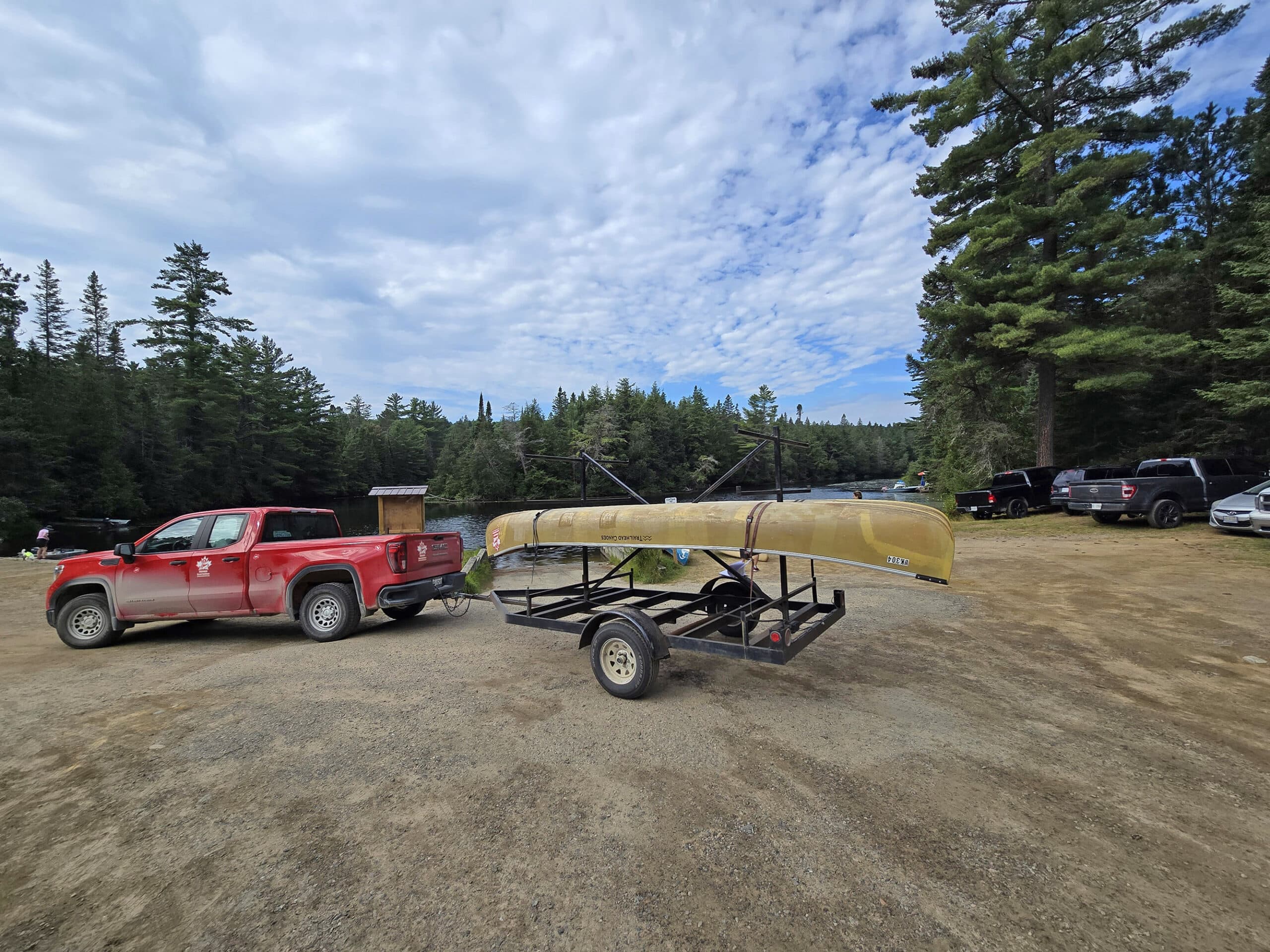 A truck with a canoe trailer, in front of the Rock Lake Campground boat launch.