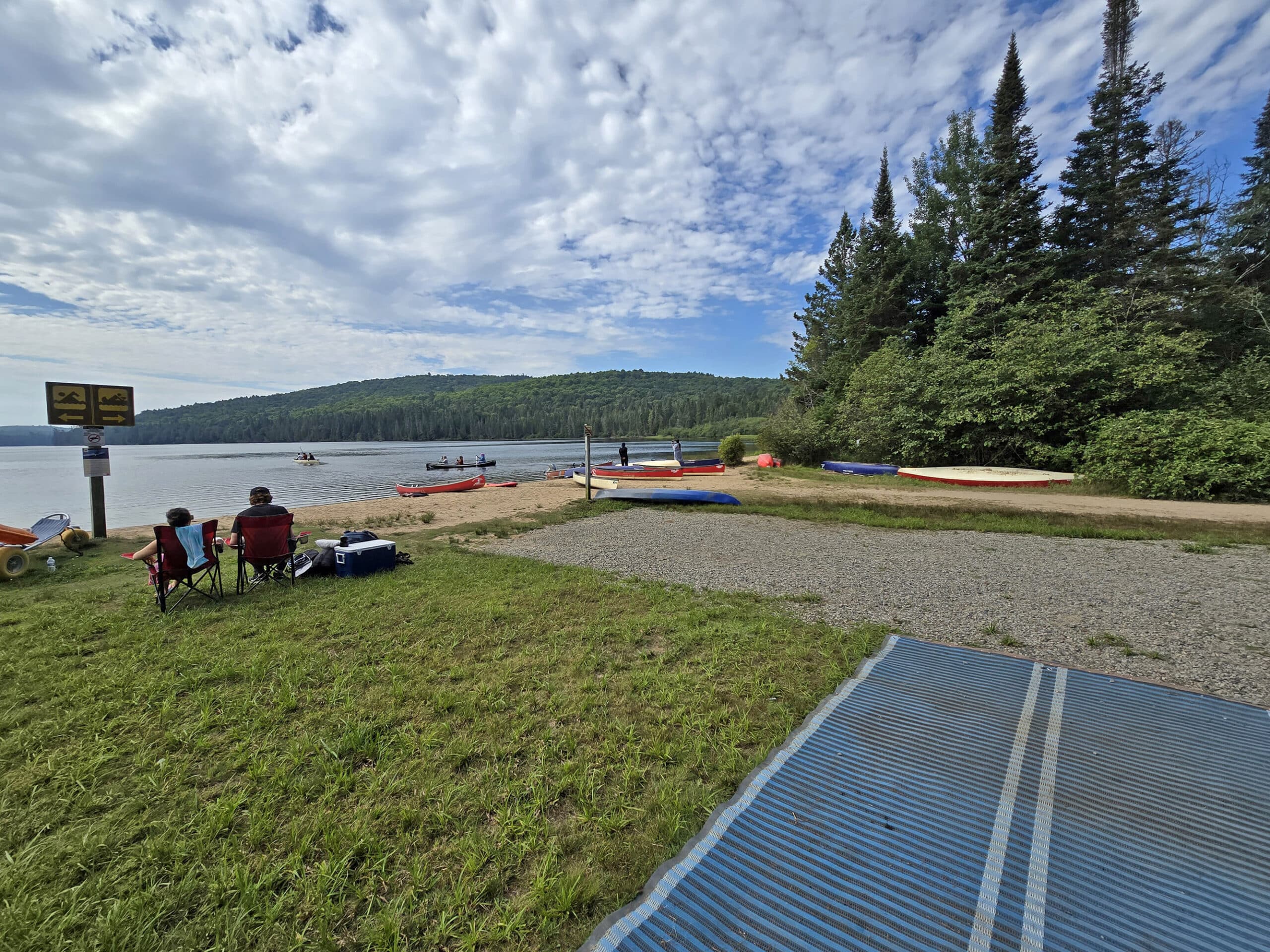 A grassy area next to the Rock Lake Campground beach, with a  blue mobi bat in the foreground.