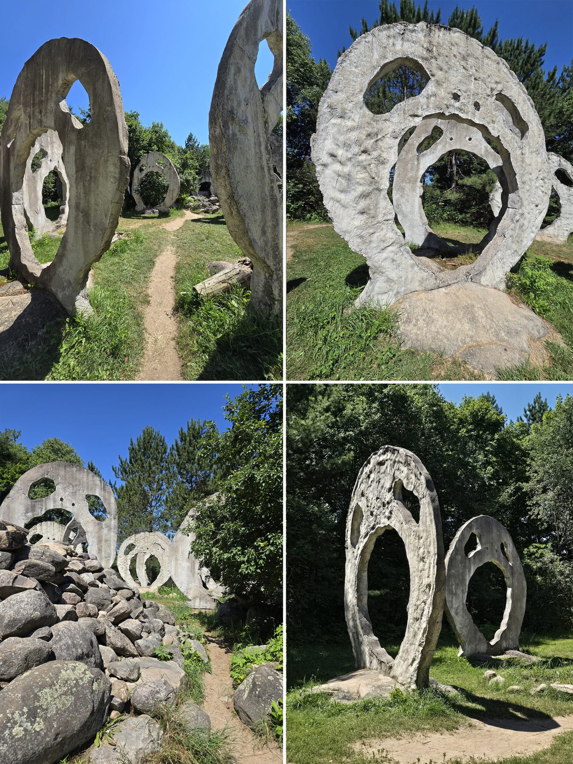 A grassy area with several 18 foot tall concrete sculptures that look like screaming heads.