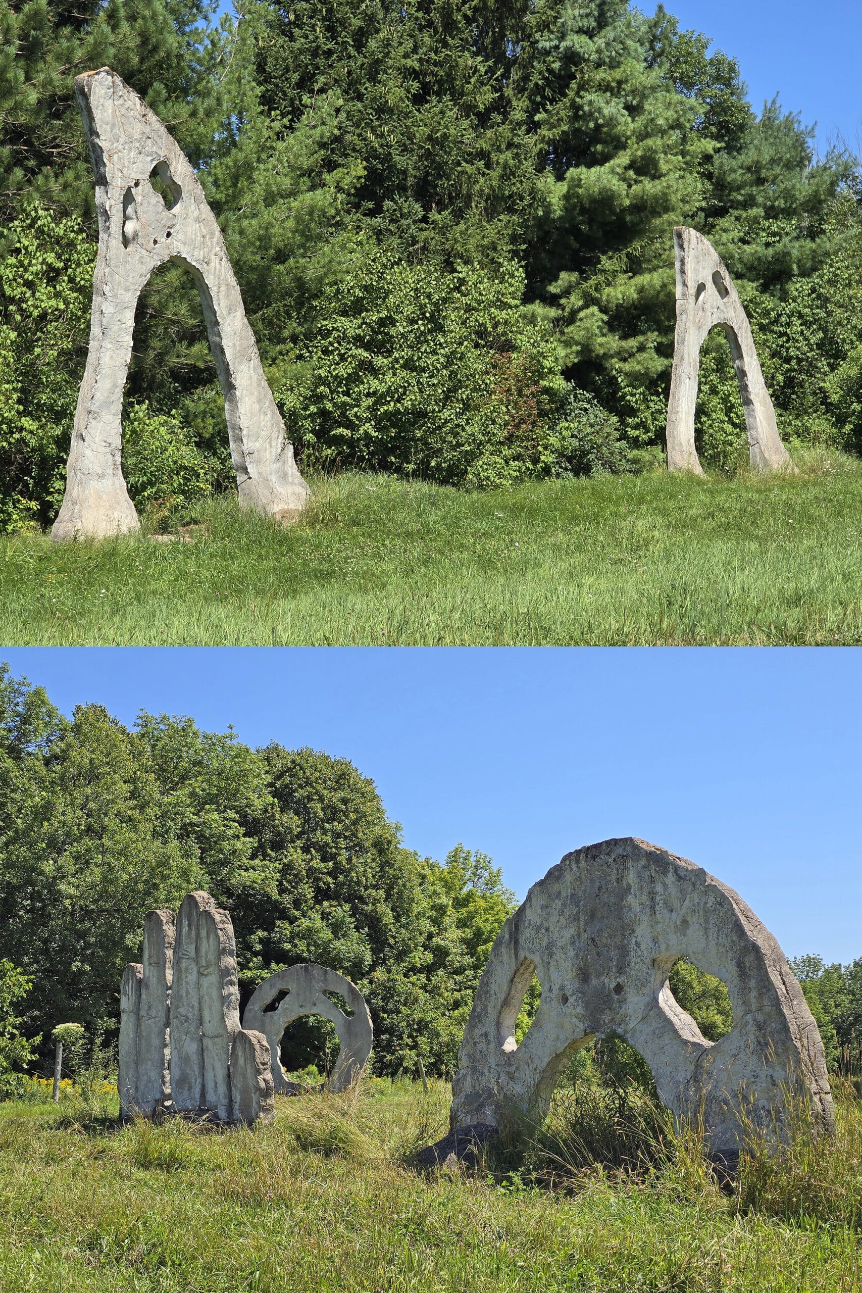 A grassy area with several 18 foot tall concrete sculptures that look like screaming heads.