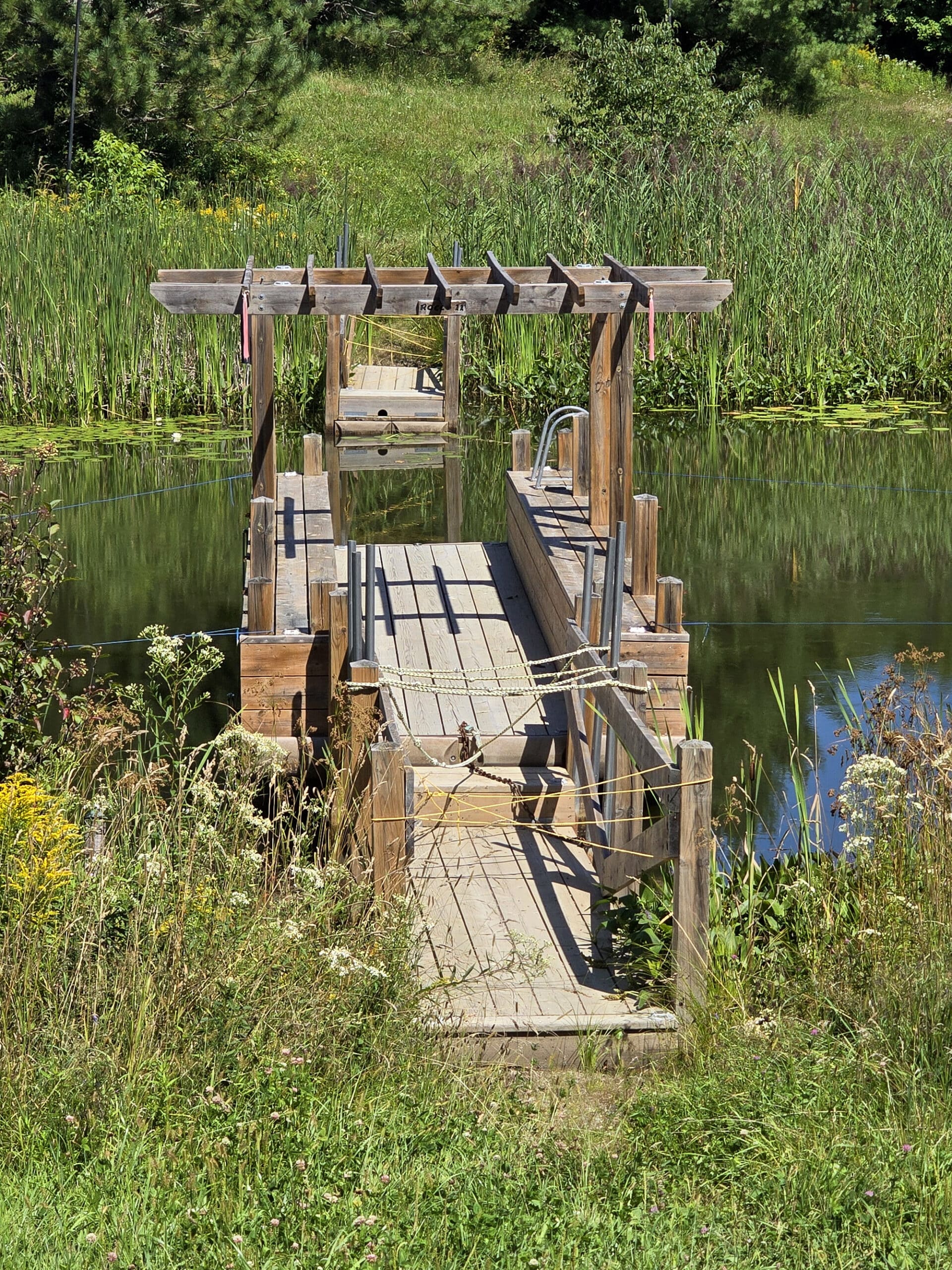 A floating wooden structure with a small dock in the background.