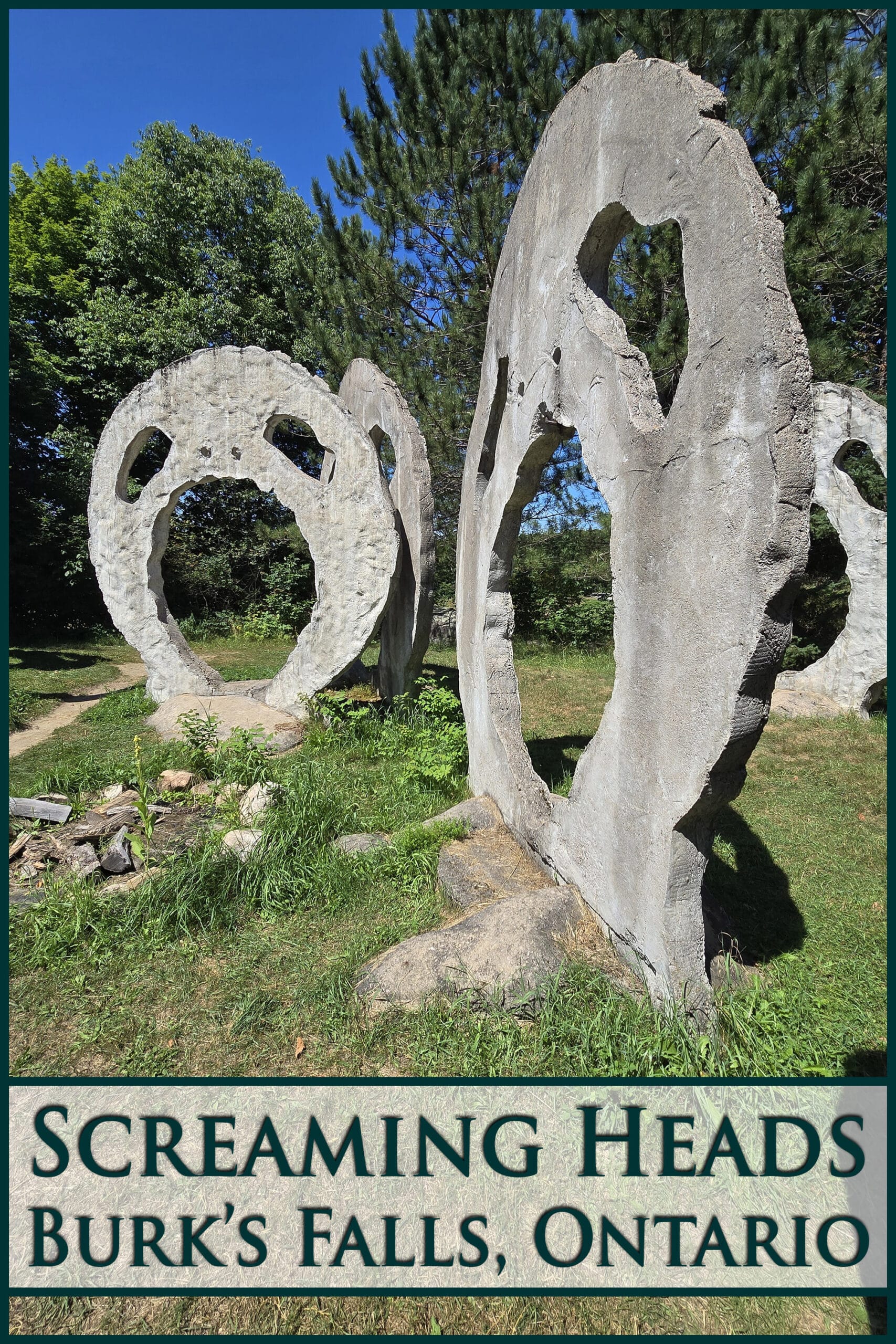 A grassy area with several 18 foot tall concrete sculptures that look like screaming heads. Overlaid text says Screaming Heads, Burk's Falls Ontario.