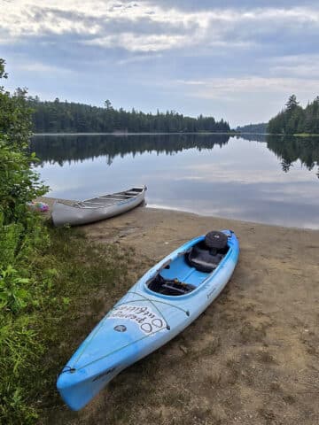 A blue kayak on the beach at Whitefish Lake campground.