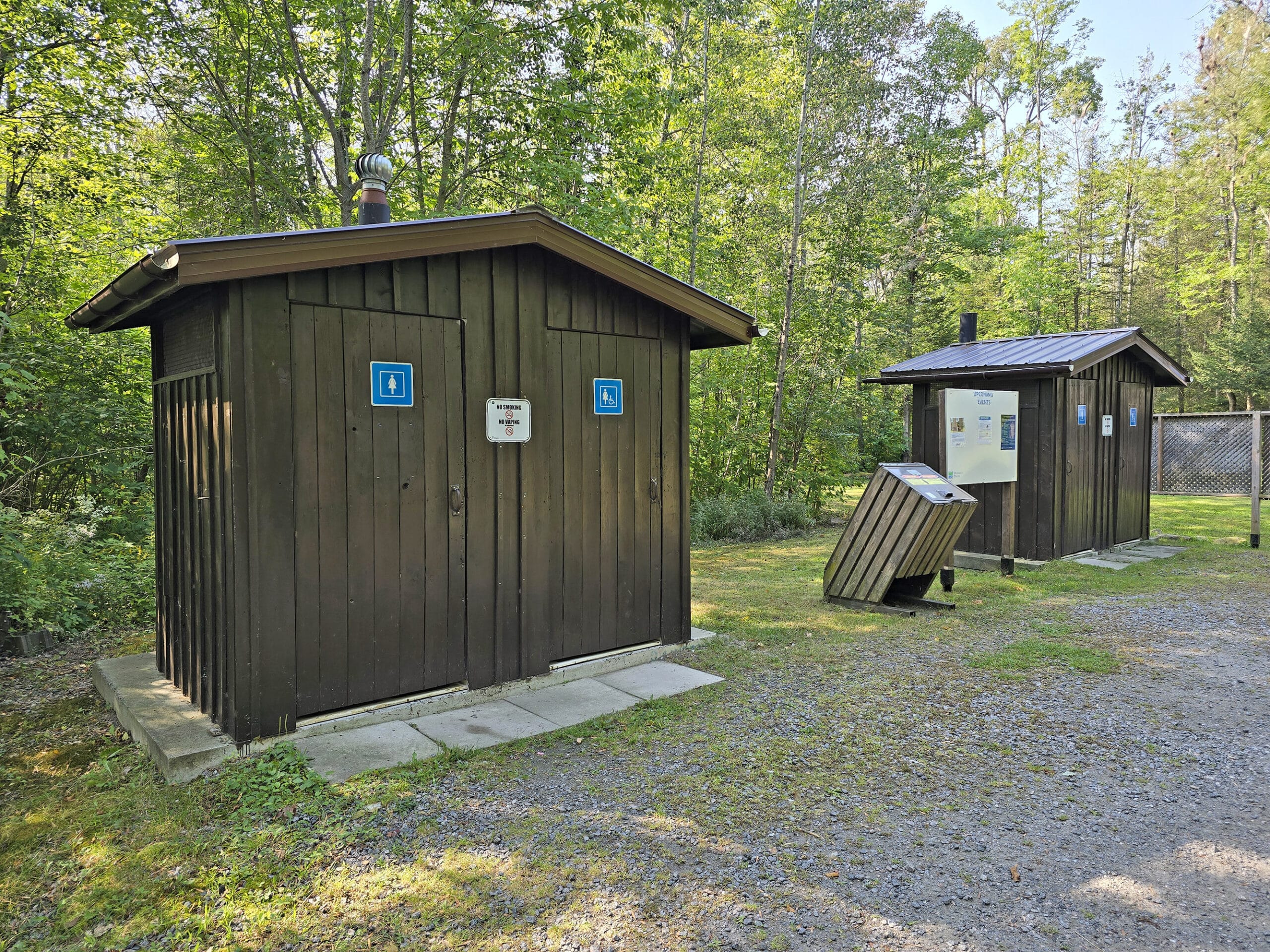 2 brown vault toilet outhouses at french river provincial park.