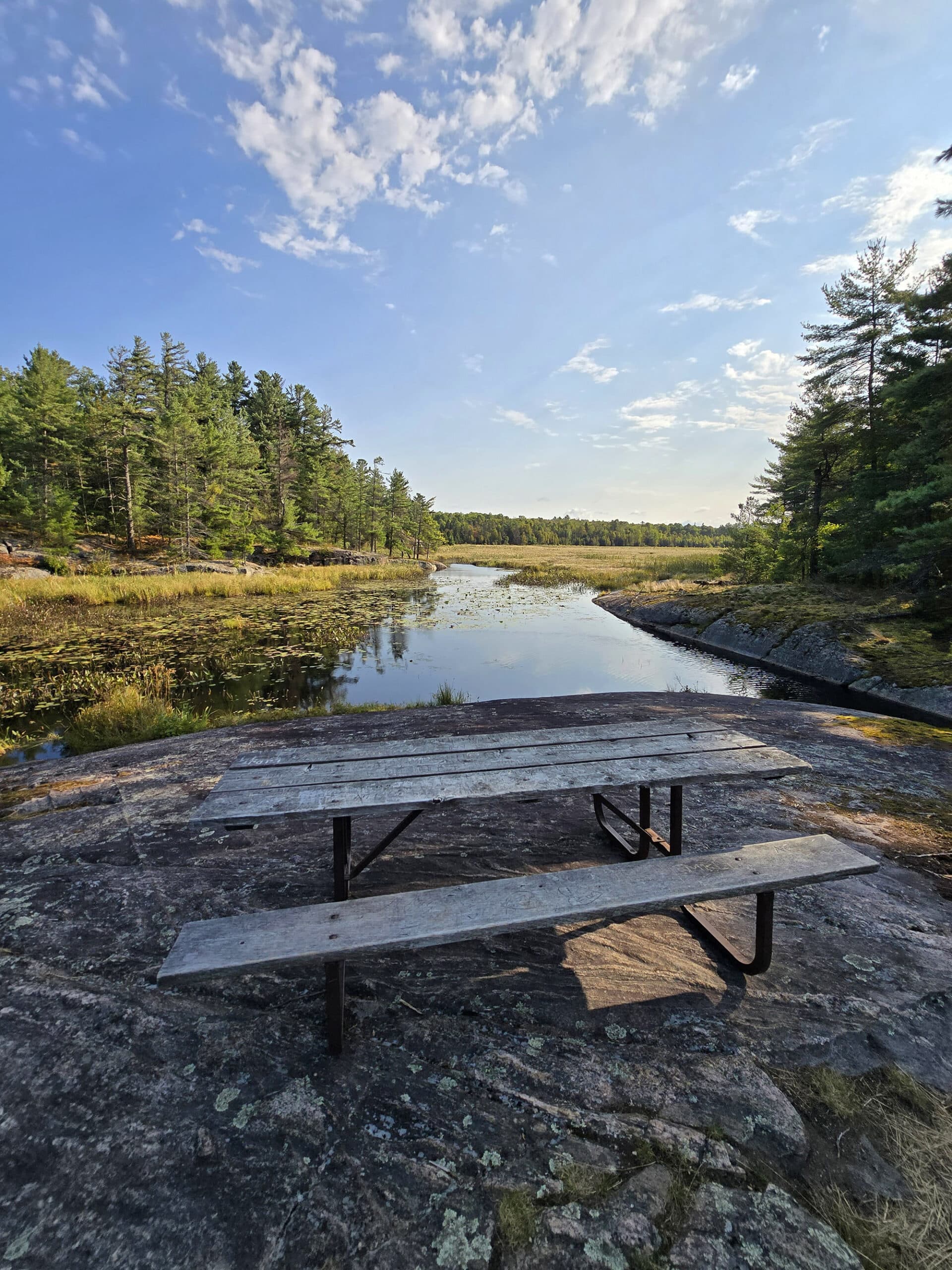 A picnic table on a rocky ledge overlooking Beaver Lake.