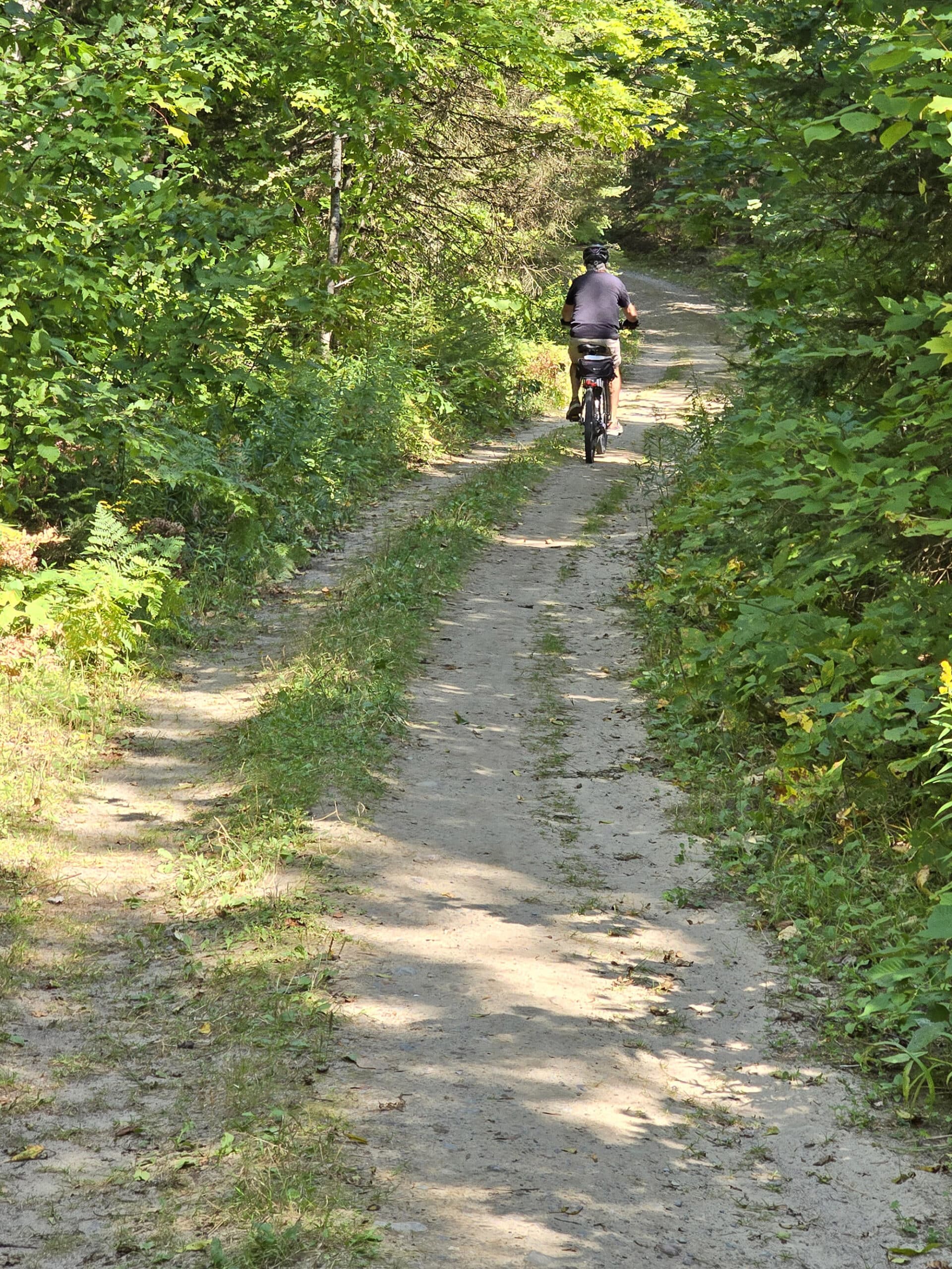 A cycling biking off into the distance on a trail.