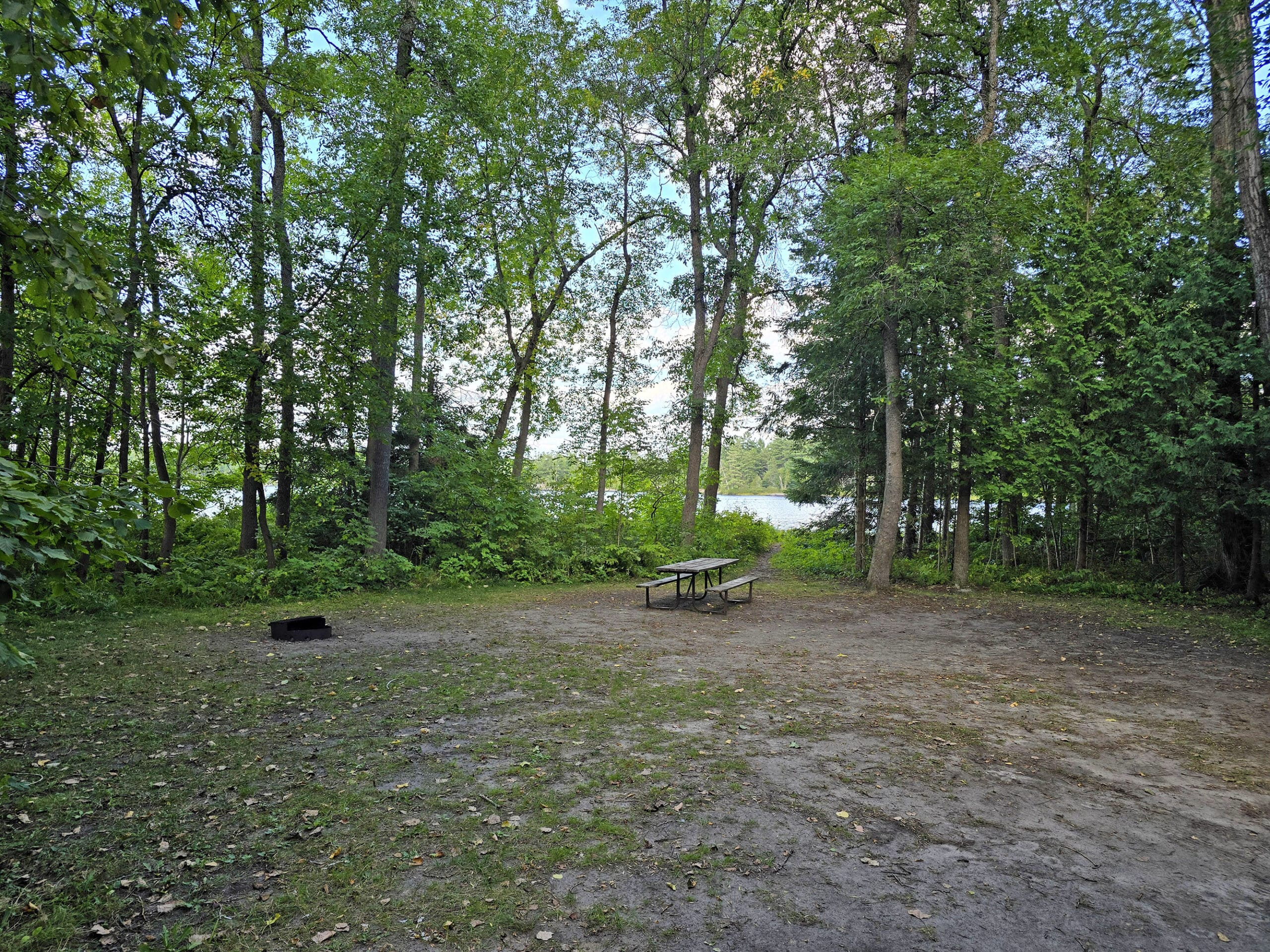 A campsite with a trail out the back, to a beach.