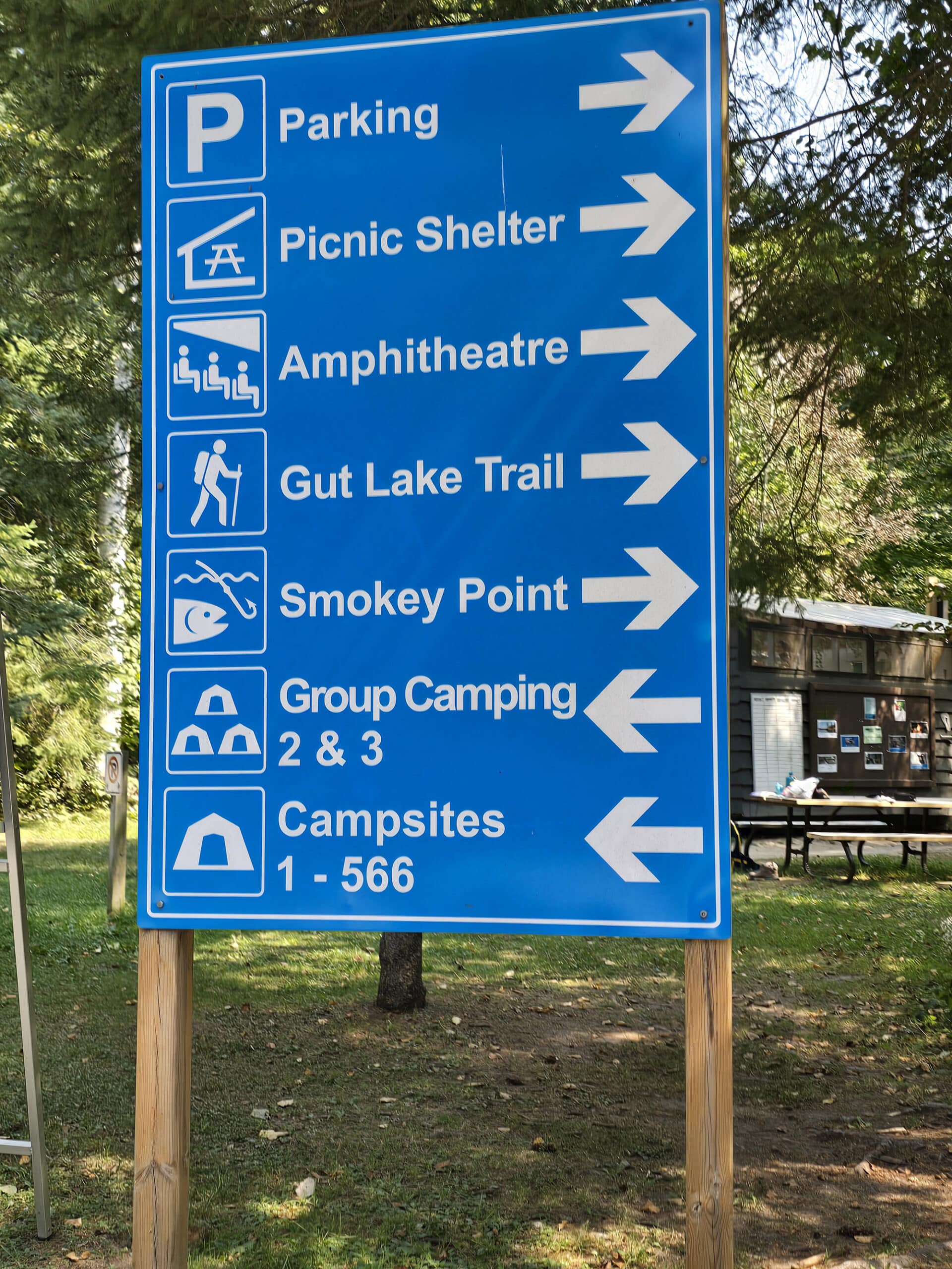 A blue road sign with directions to various destinations.