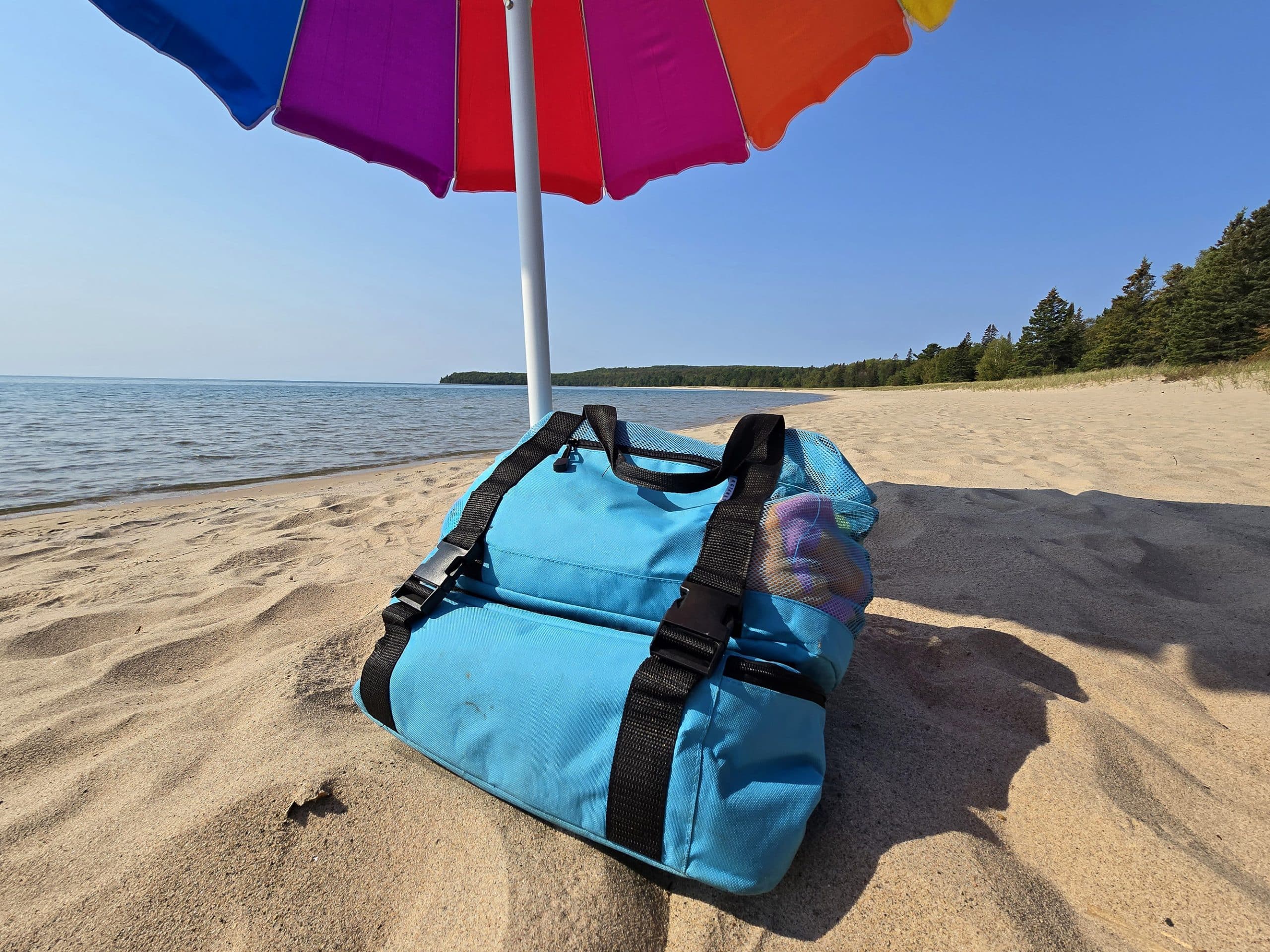 A beach bag and umbrella on pancake bay beach.