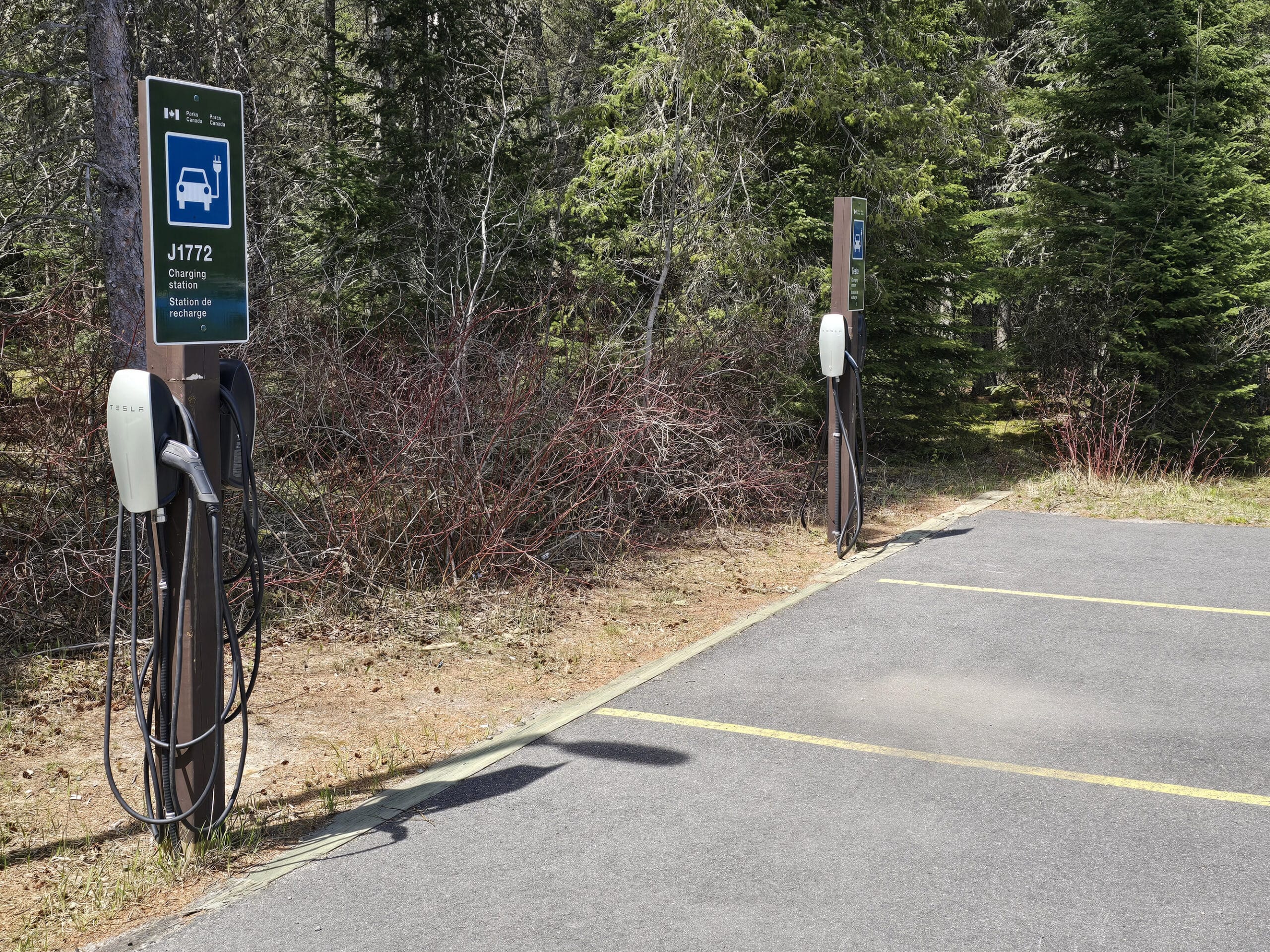2 EV charging stations in a Pukaskwa Provincial Park parking lot.