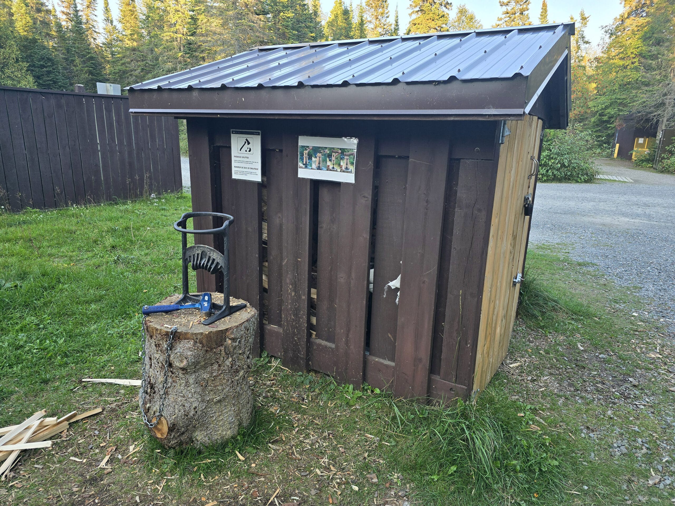 A small wooden shack with a wood splitting took in front.