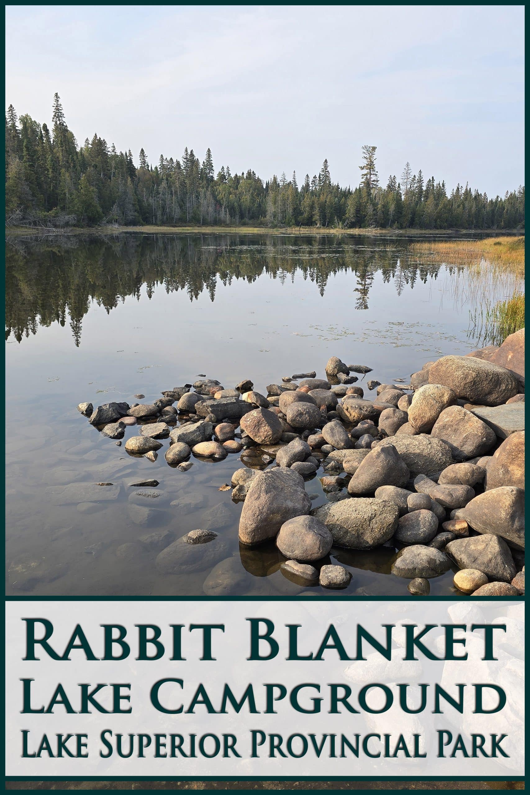 A lake just after sunrise. Overlaid text says Rabbit Blanket Lake Campground Lake Superior Provincial Park.