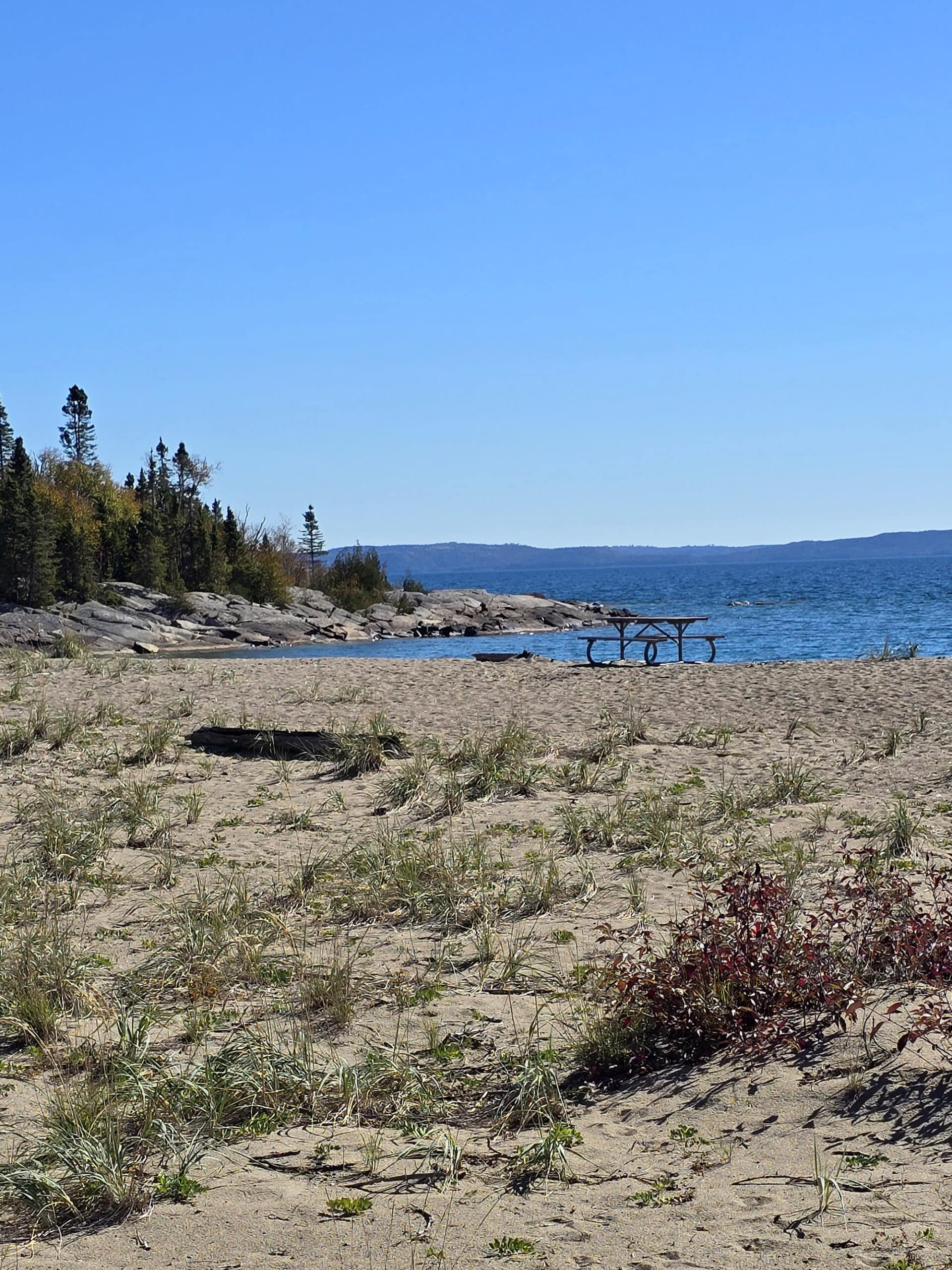 Picnic tables on a rocky terrace bay beach.