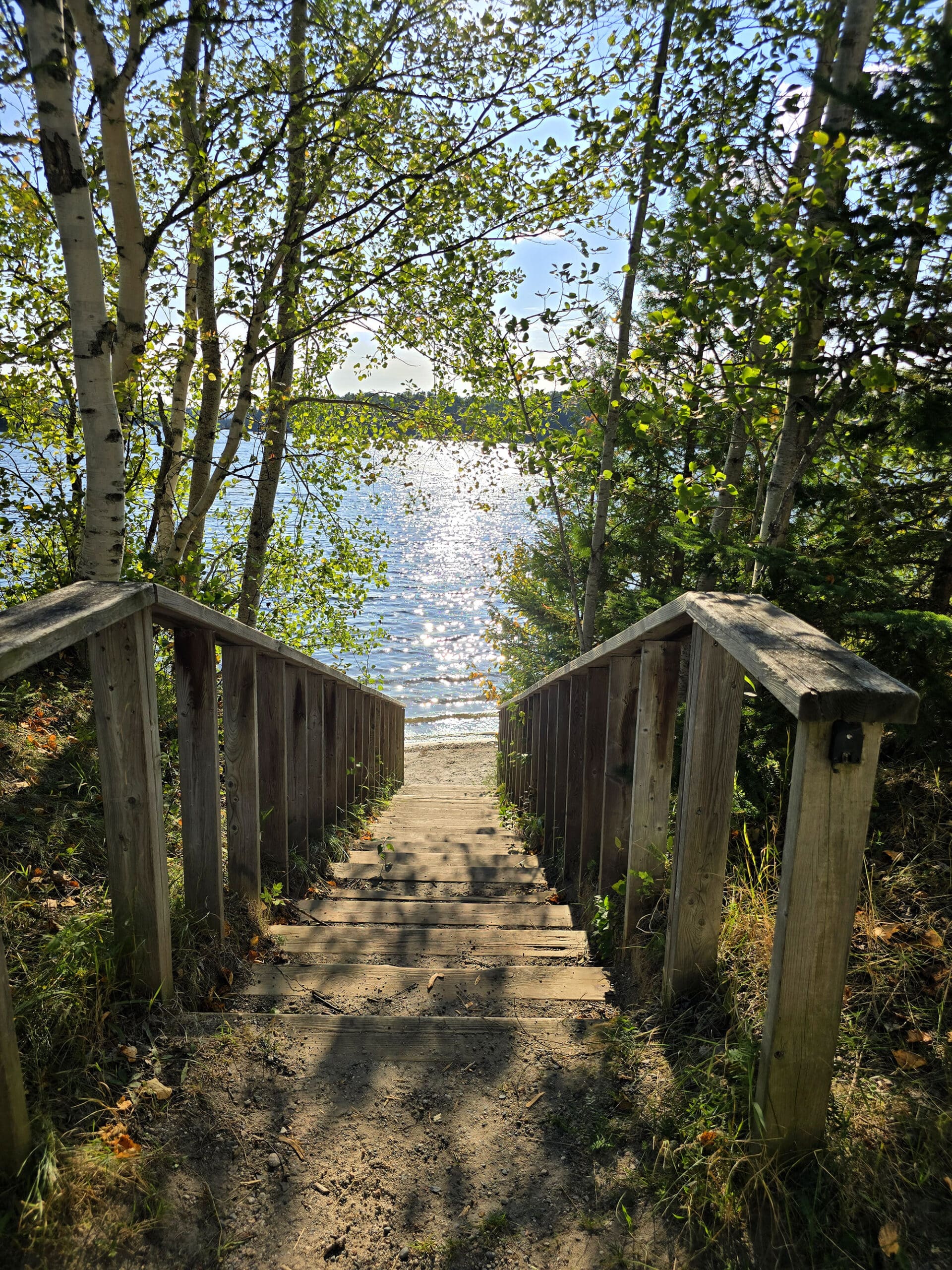 A wooden staircase descending to white lake.