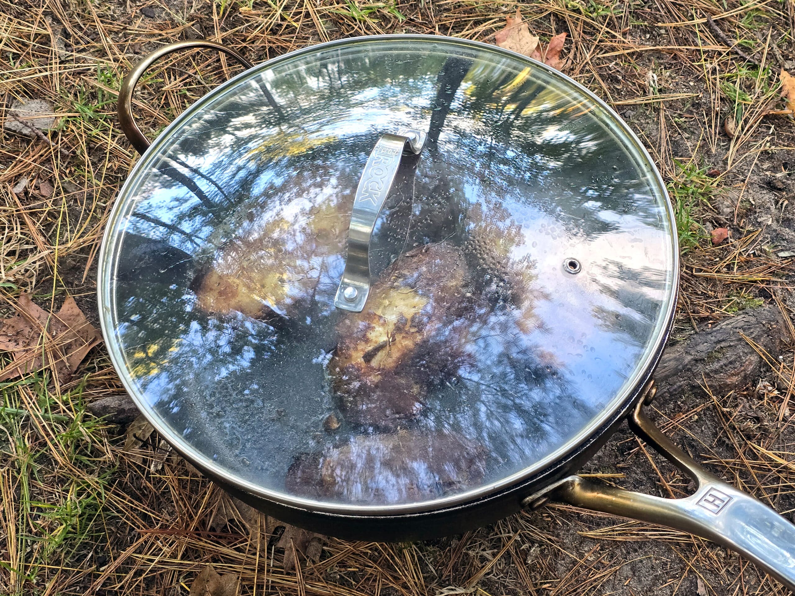 A pan of apple fritter french toast with a lid on it, sitting on the ground.