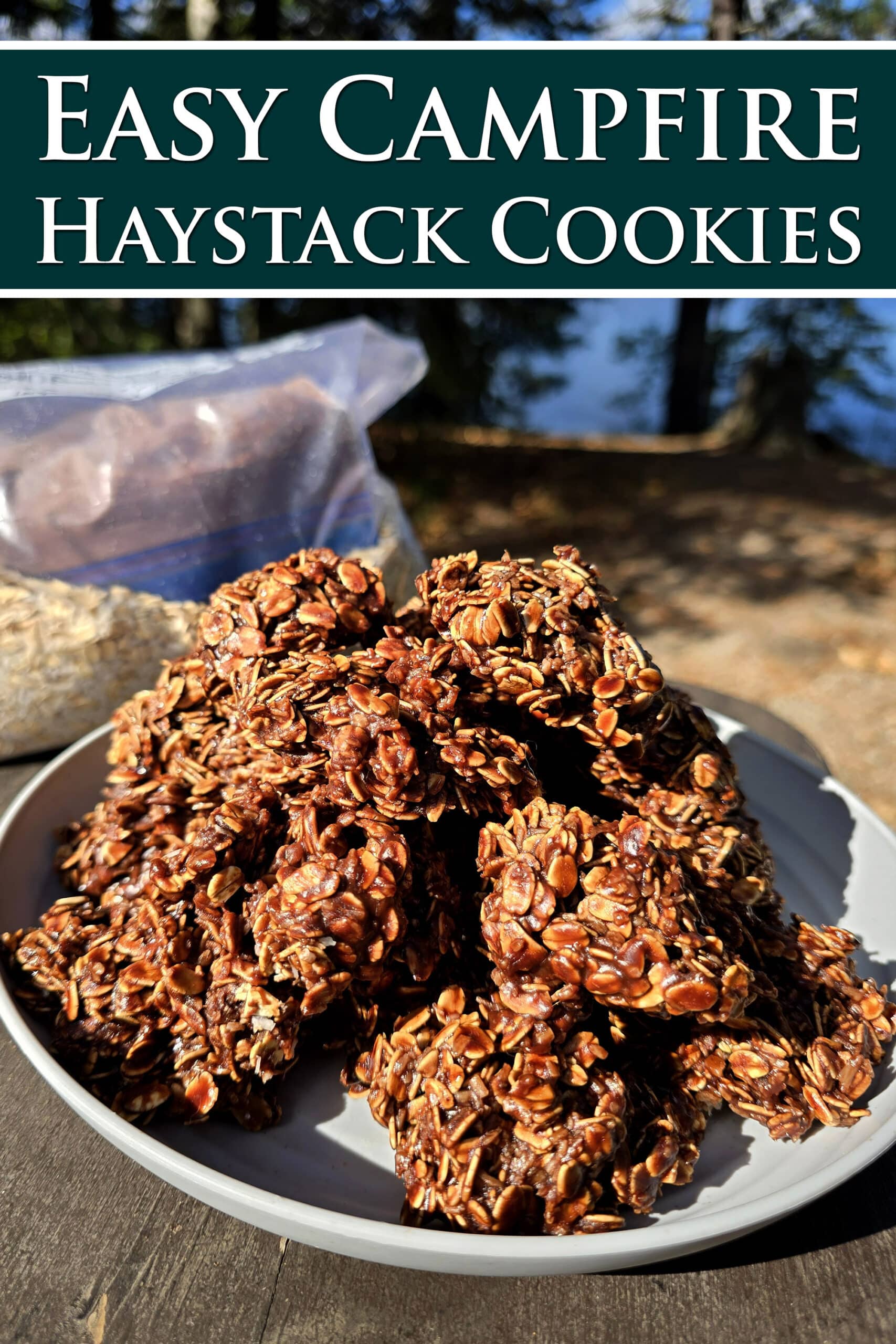 A plate of chocolate haystack cookies on a picnic table, in front of a bag of homemade cookie mix.  Overlaid text says easy campfire haystack cookies.