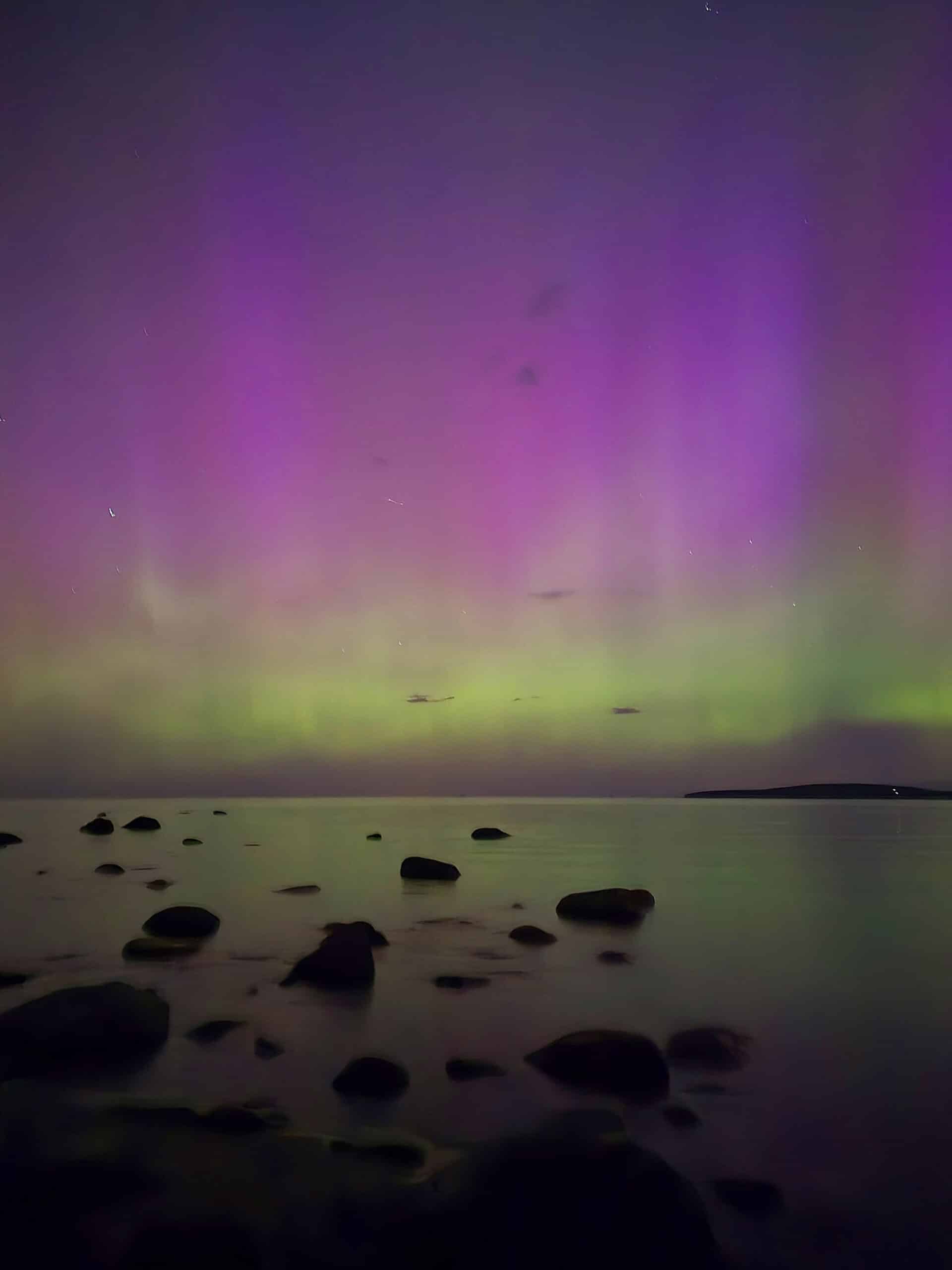 Bright pink and purple aurora borealis display at awenda Provincial Park.