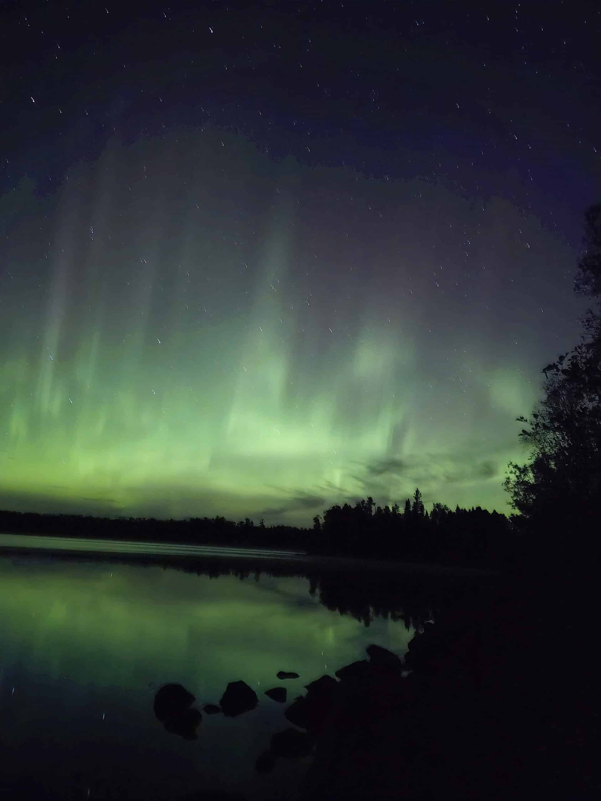 A bright green and pink aurora borealis display in Ontario.