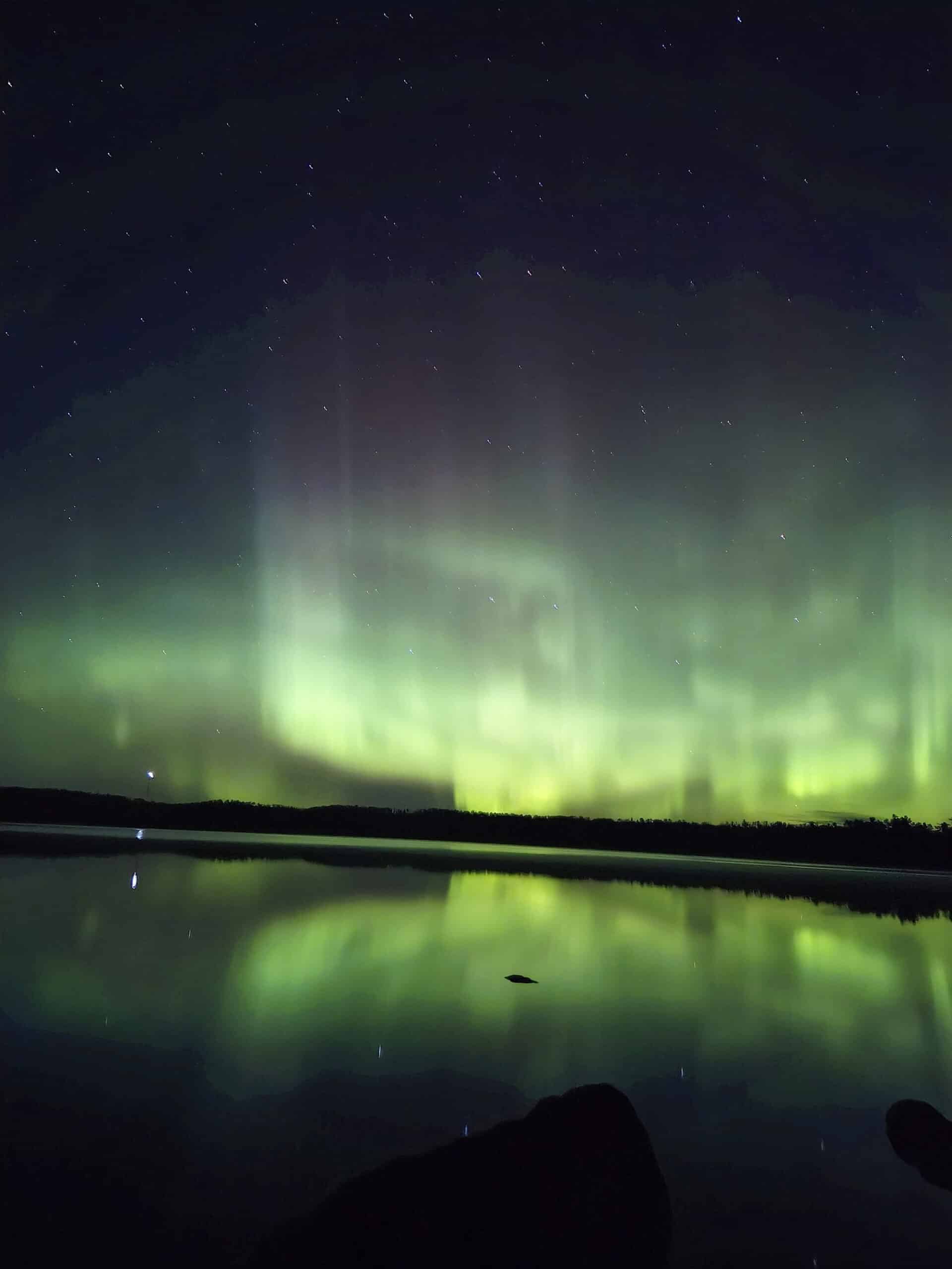 A bright green and blue northern lights display in Ontario.