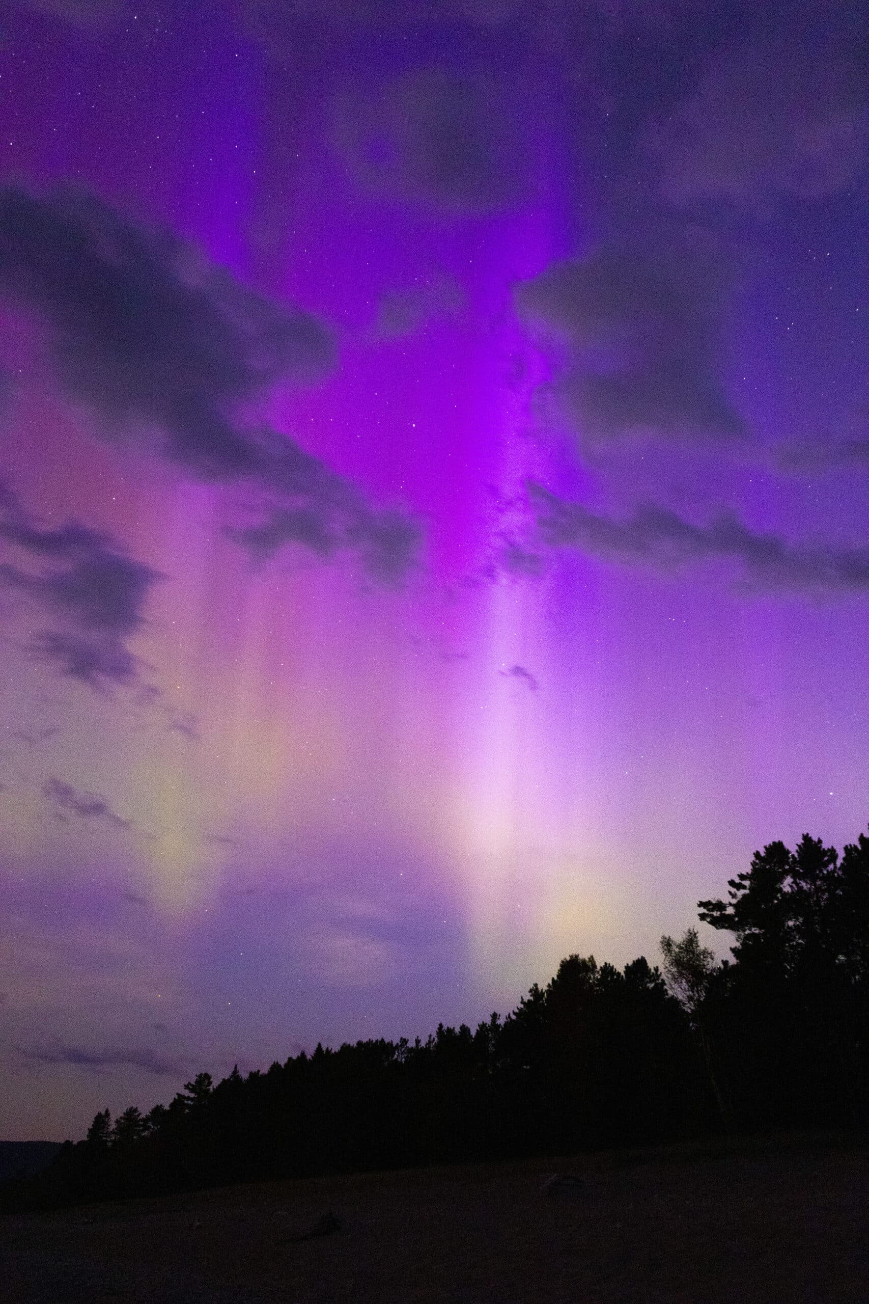 Green and purple streaks of light in the sky due to aurora borealis.