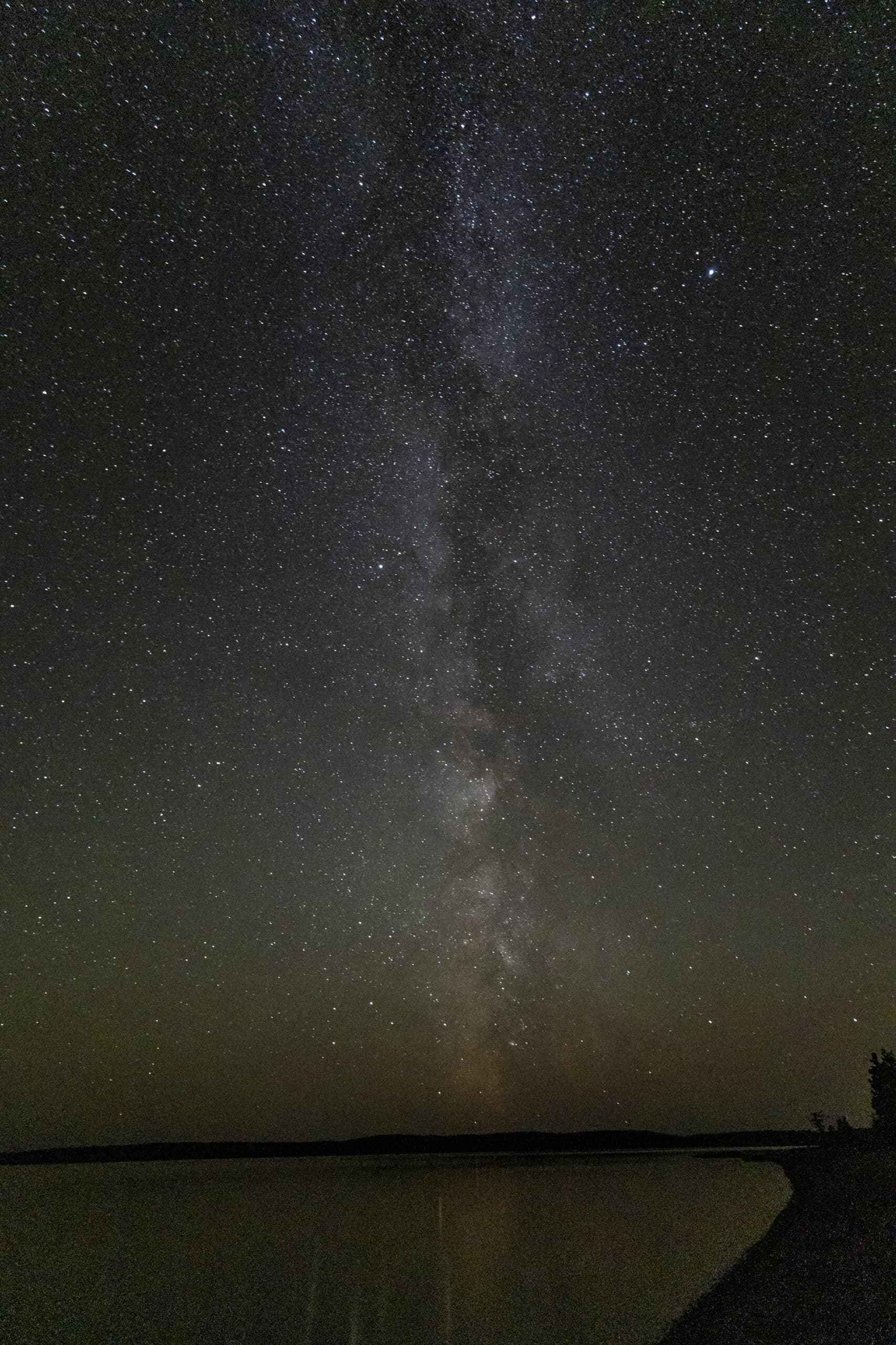 A photo of the Milky way, many stars of varying intensity in the sky, aligned somewhat in a straight line.