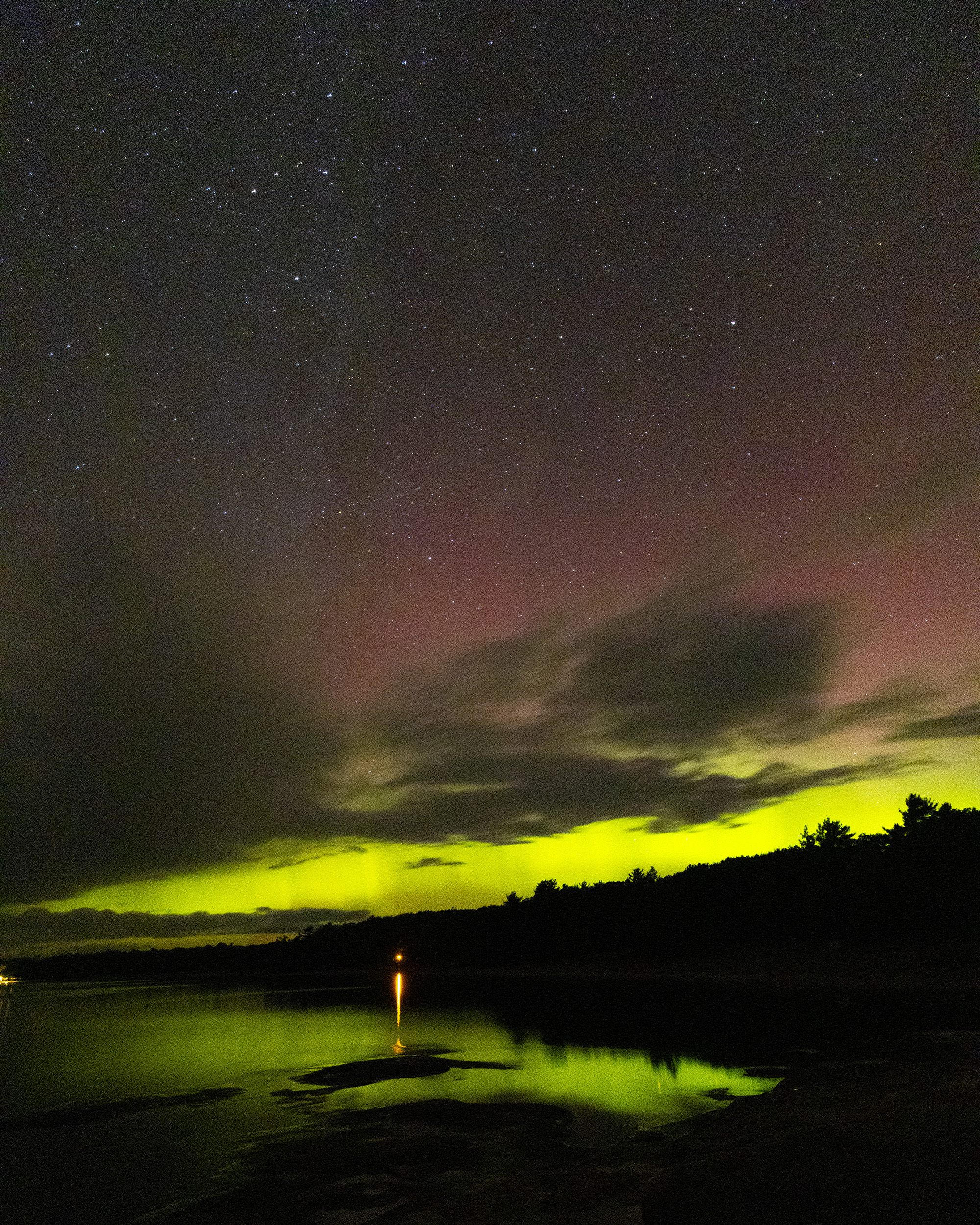 Green and red streaks of light in the sky due to aurora borealis.