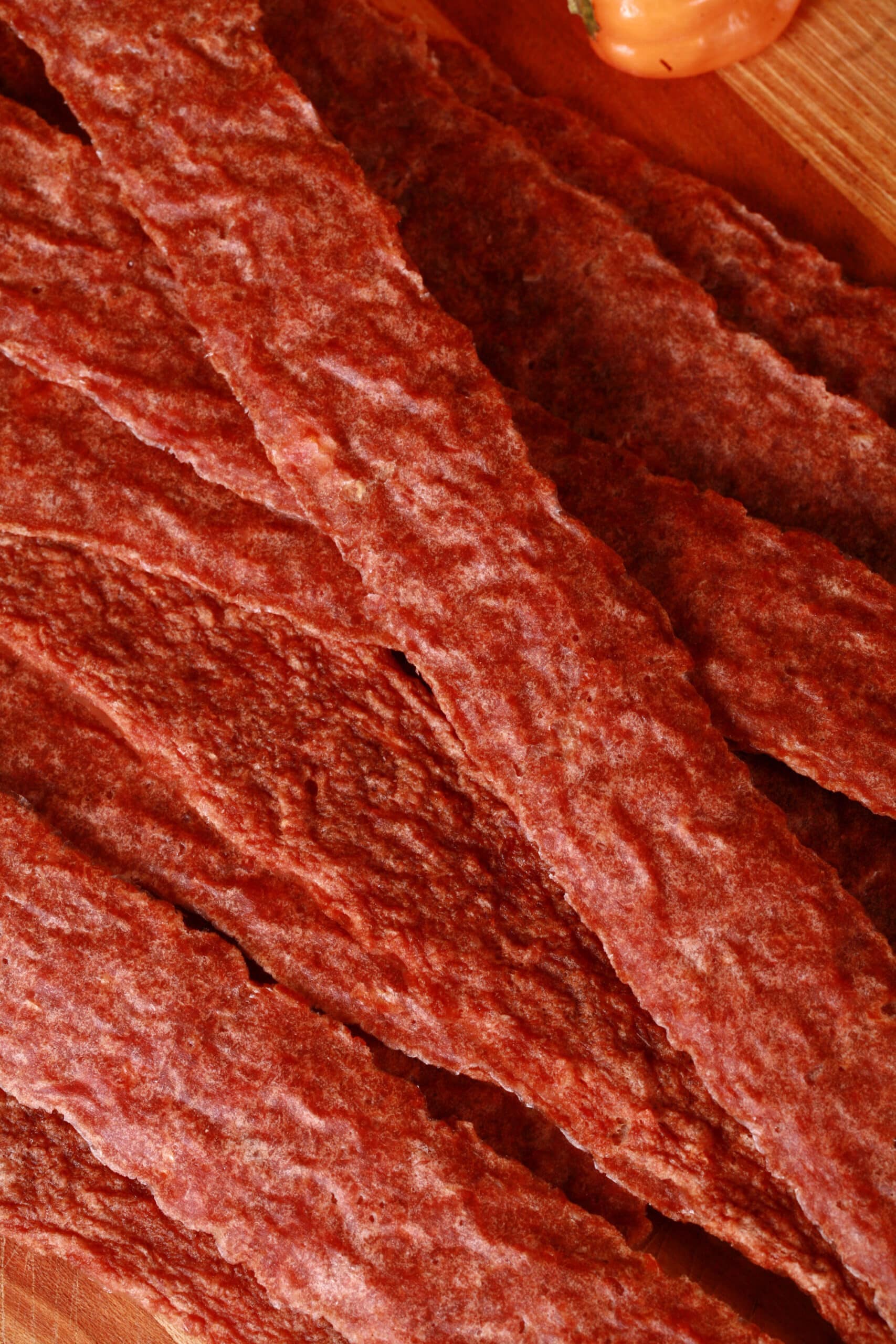 A pile of mango habanero chicken jerky on a cutting board.