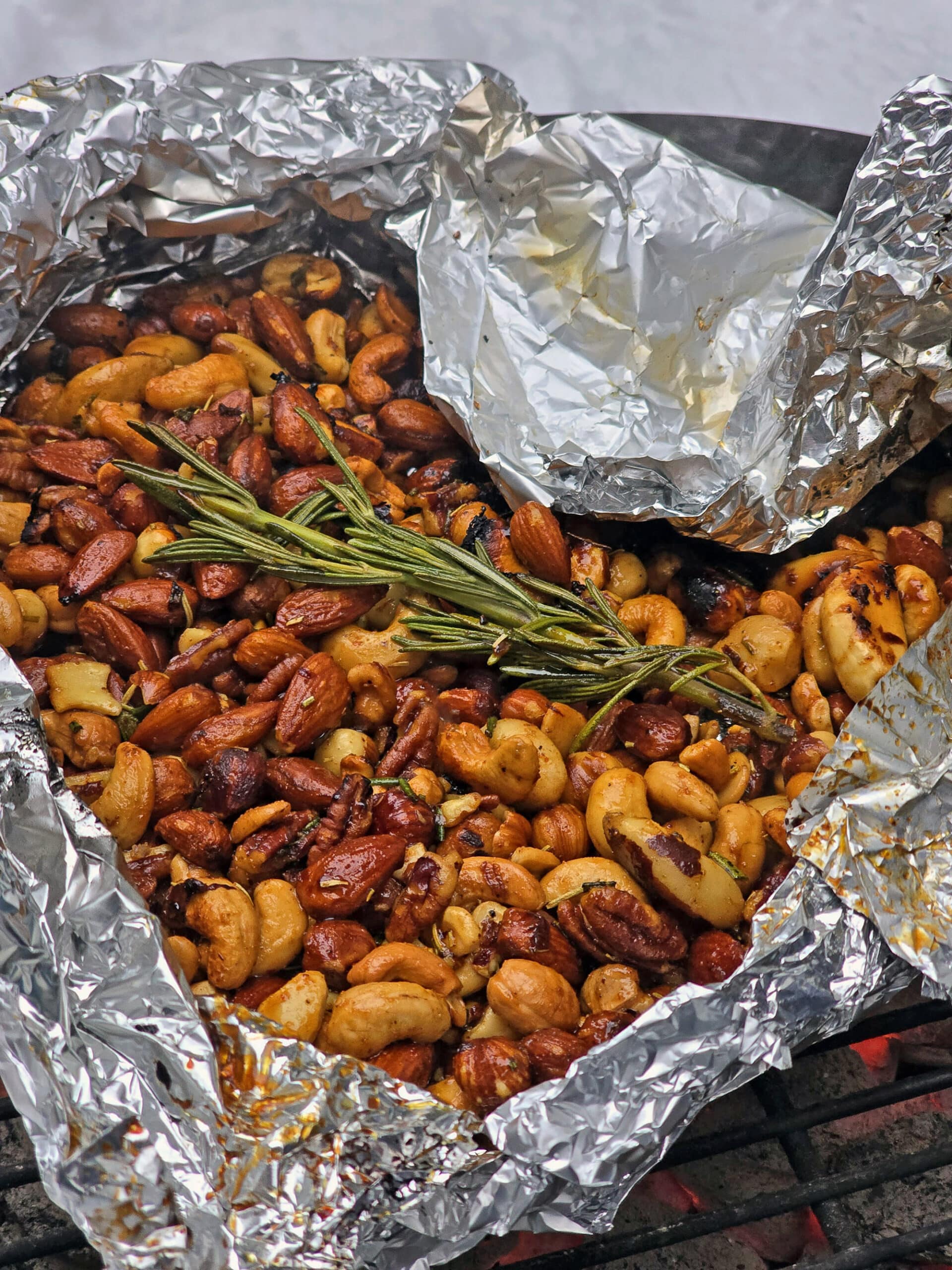 A foil packet of fire roasted spiced nuts on a snowy picnic table.