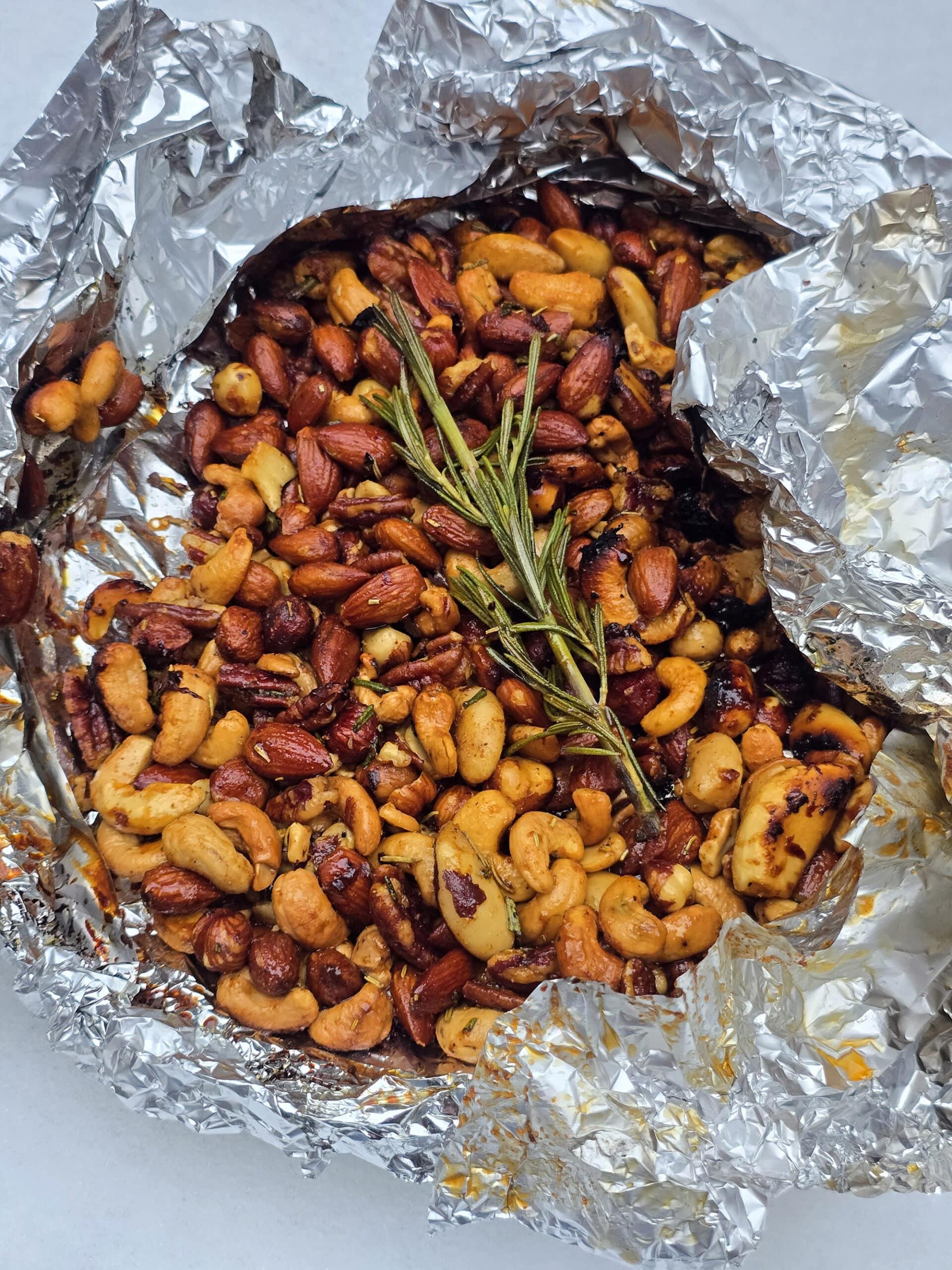 A foil packet of fire roasted spiced nuts on a snowy picnic table.