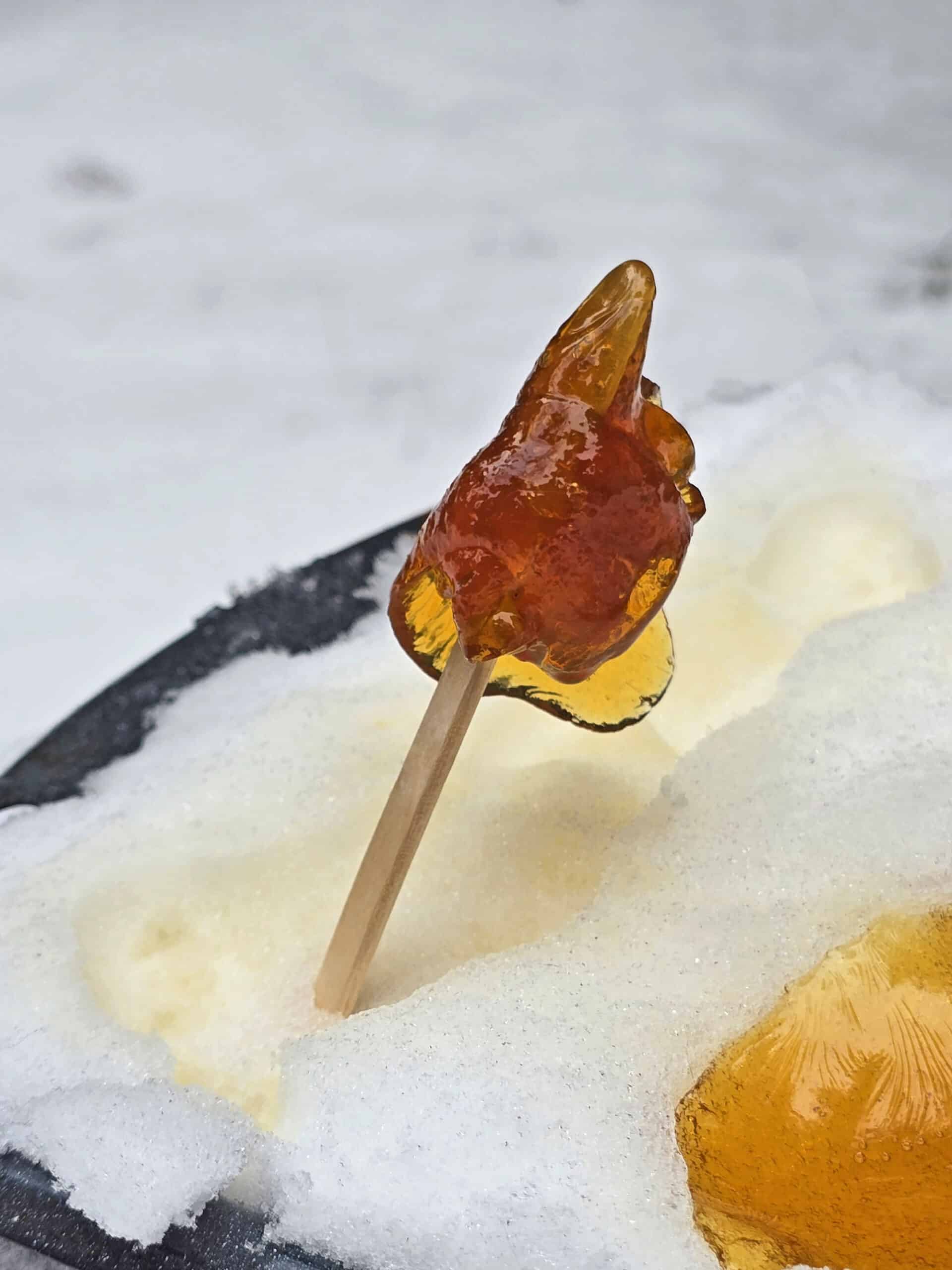 A popsicle stick with maple taffy on it.