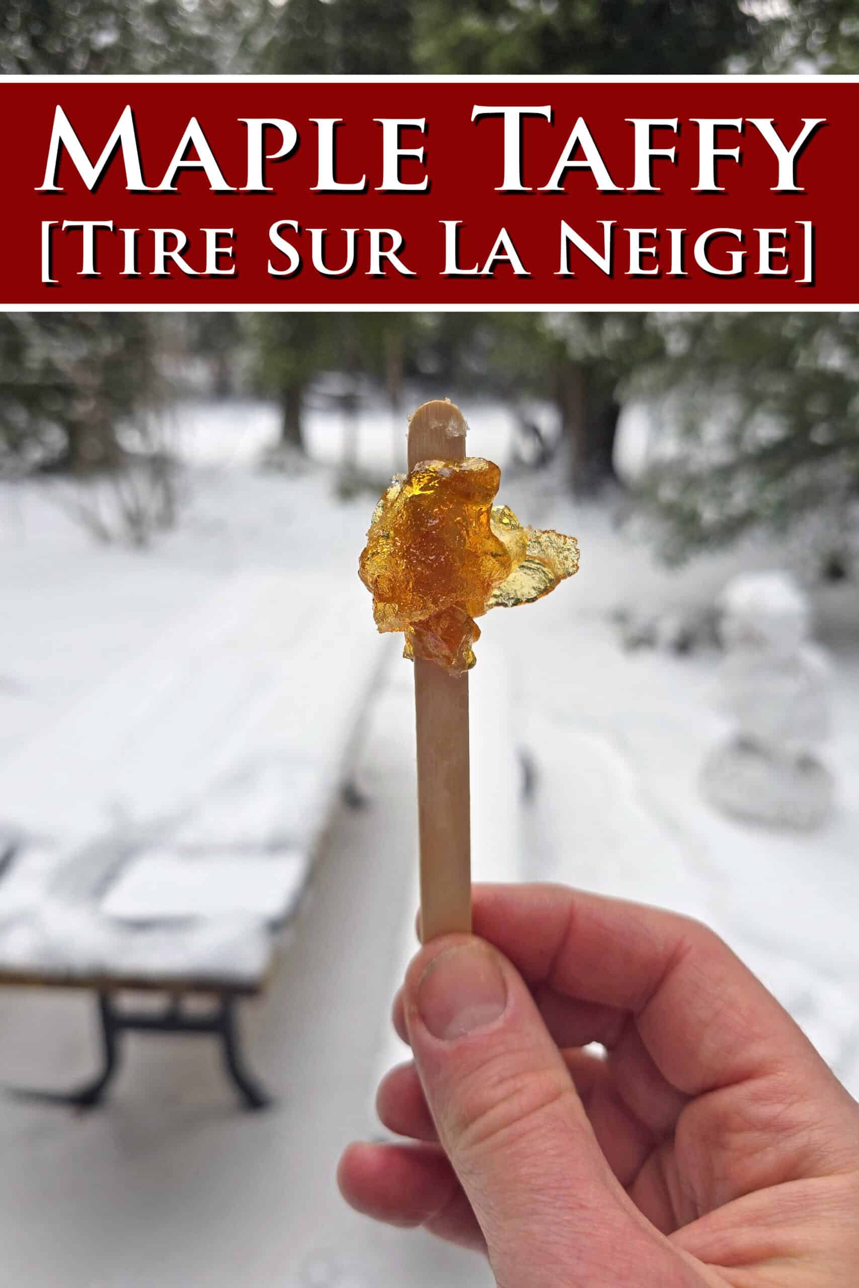 A hand holding a popsicle stick with maple syrup snow taffy on it. Overlaid text says maple taffy tire sur la neige.