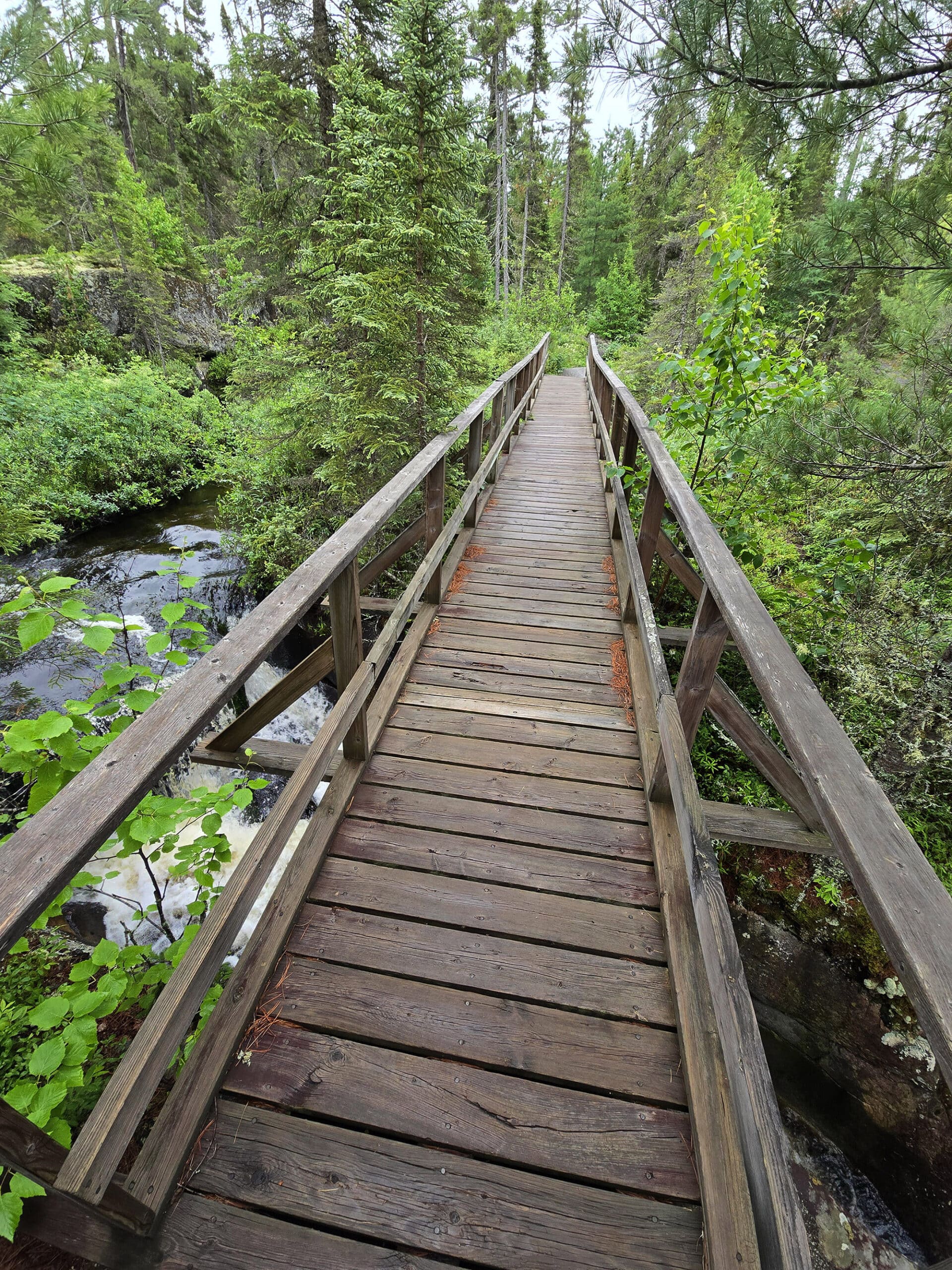A bridge between a stream and the glacial potholes at Potholes Provincial Park.