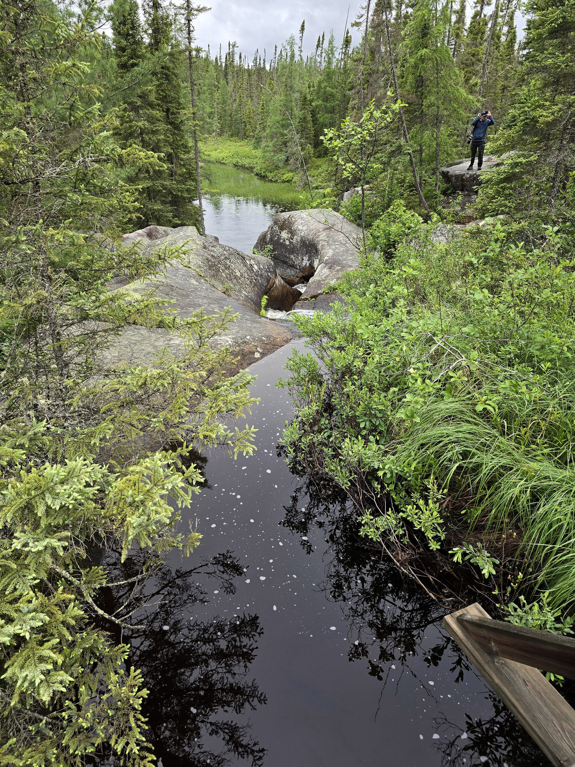A stream and rocks looking down over a valley.