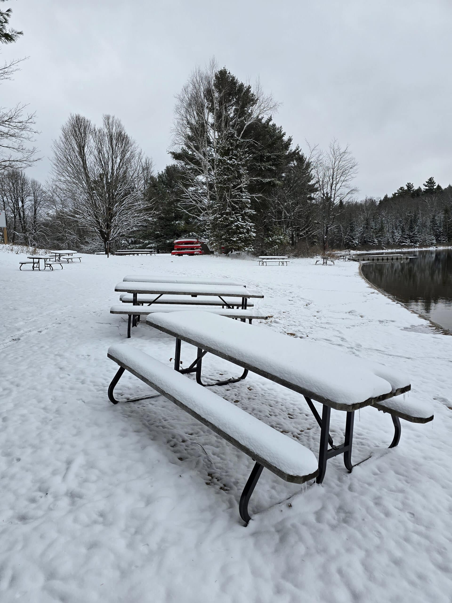 A snow covered view of the silent lake provincial park day use area and beach, in the winter.