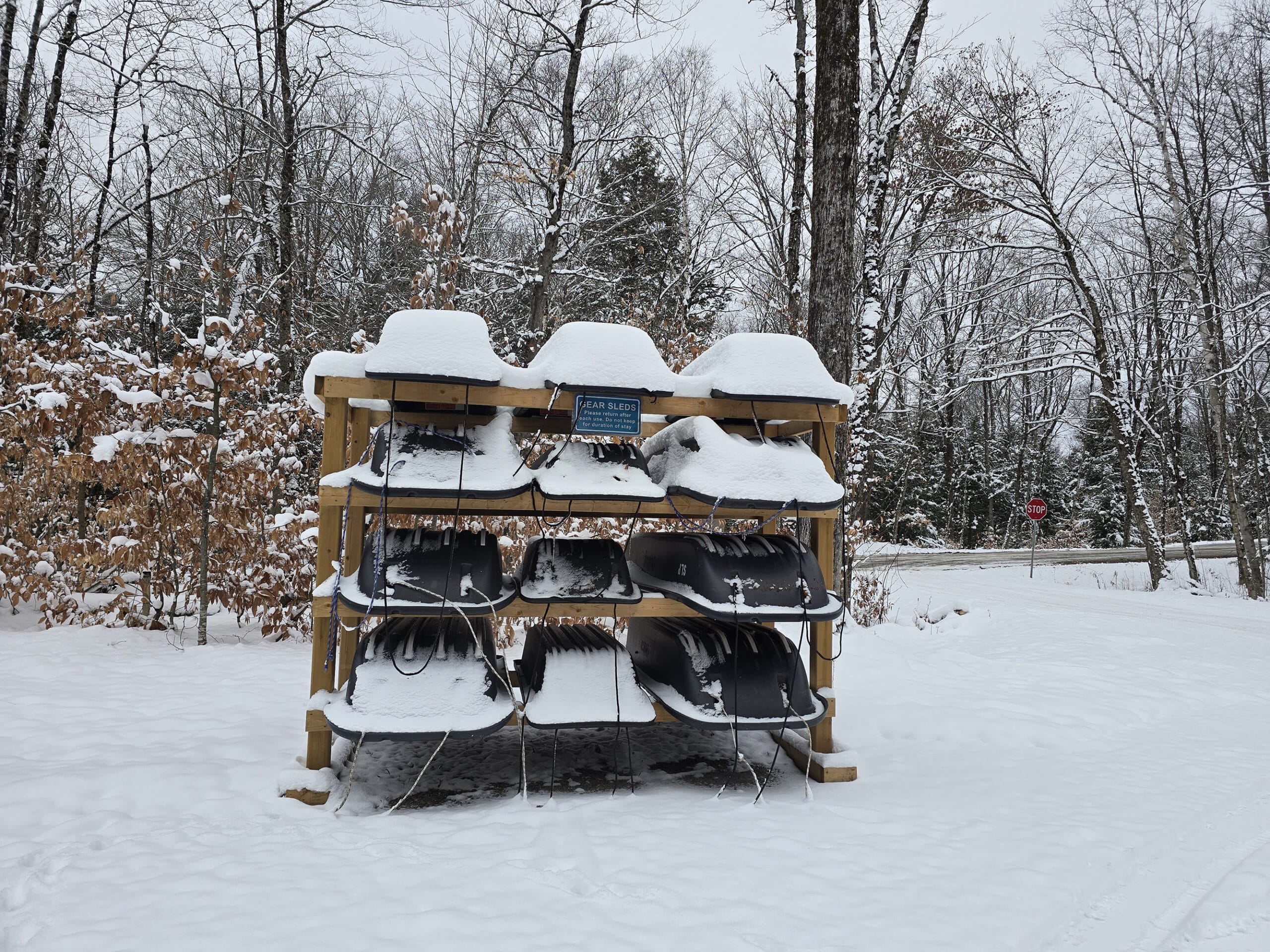 A rack of toboggans in the parking lot.