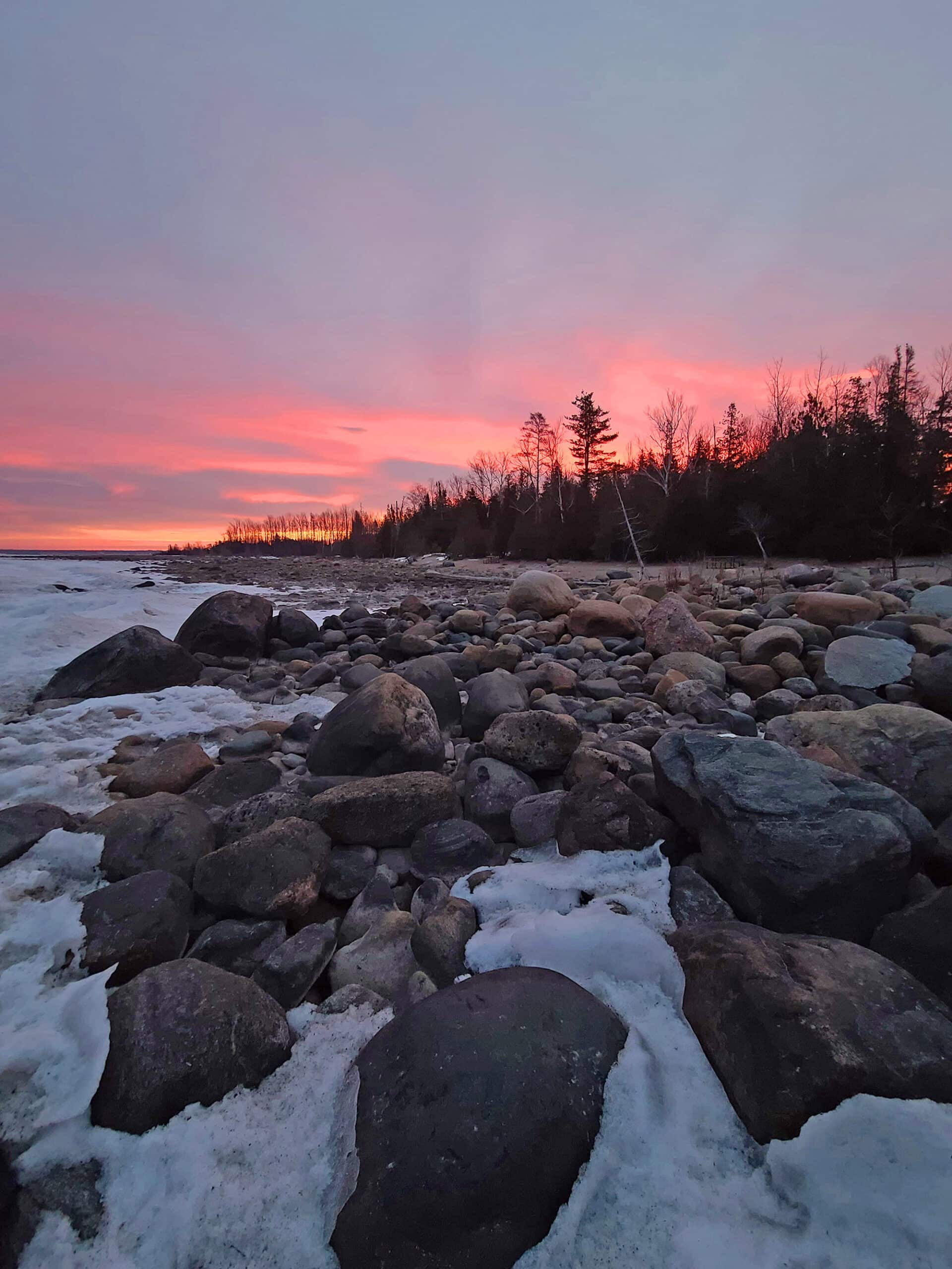 Sunrise over a snowy Lake Huron Beach.