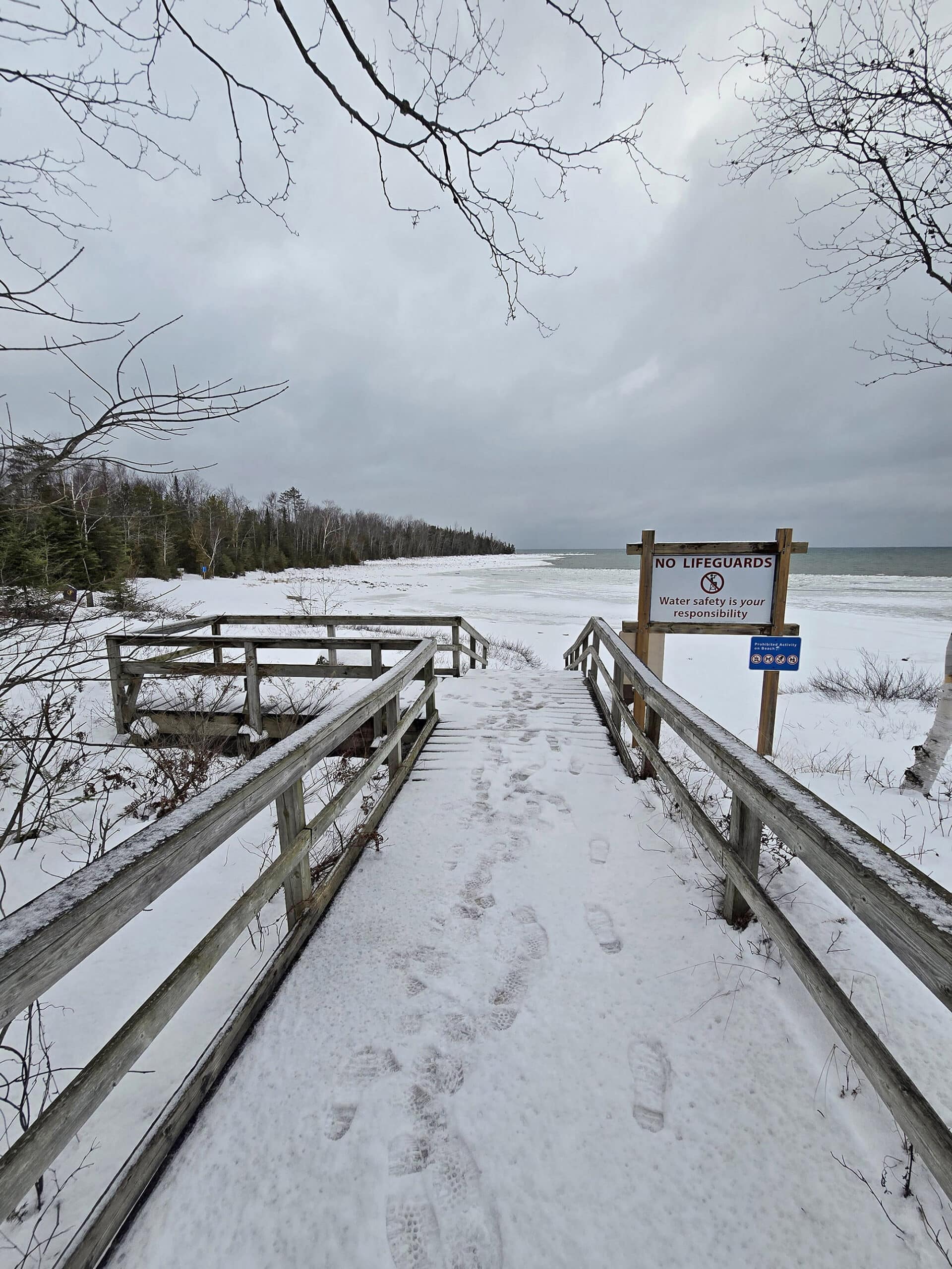 A snow covered boardwalk leading to a MacGregor Point Provincial Park beach.