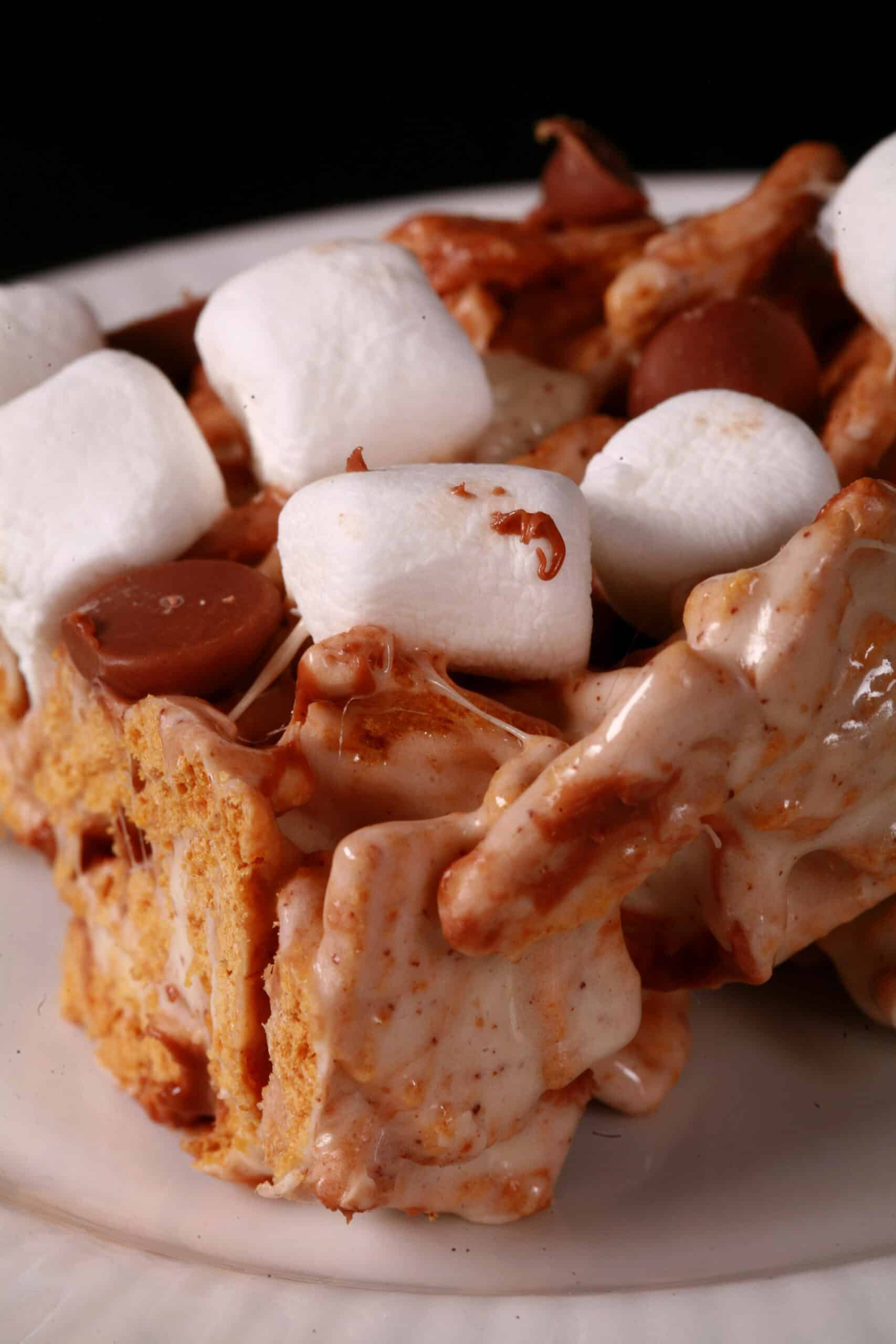 A no-bake smores bar made with golden grahams cereal, melted marshmallows, mini marshmallows, browned butter, and chocolate chips.