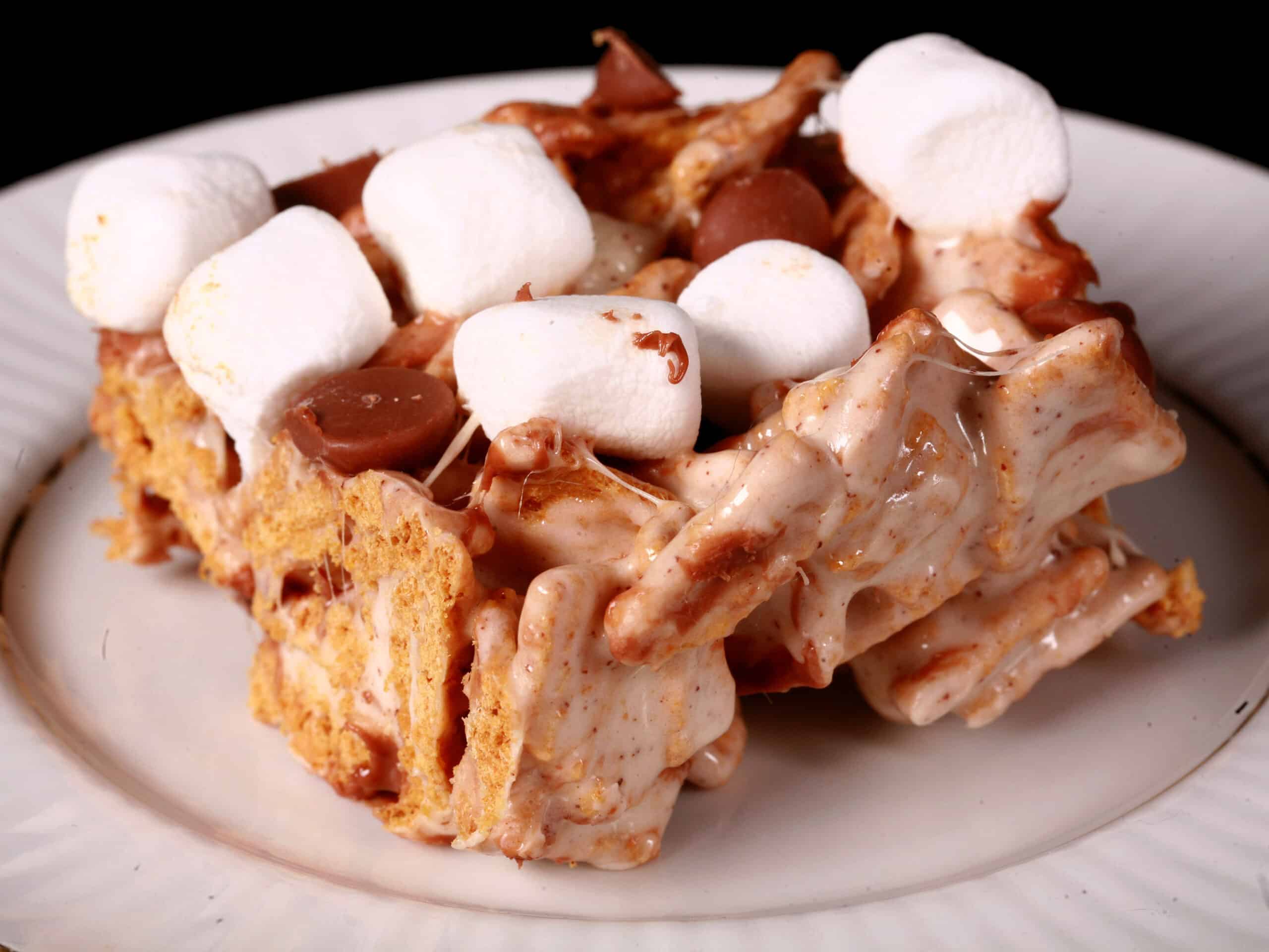 A no-bake smores bar made with golden grahams cereal, melted marshmallows, mini marshmallows, browned butter, and chocolate chips.