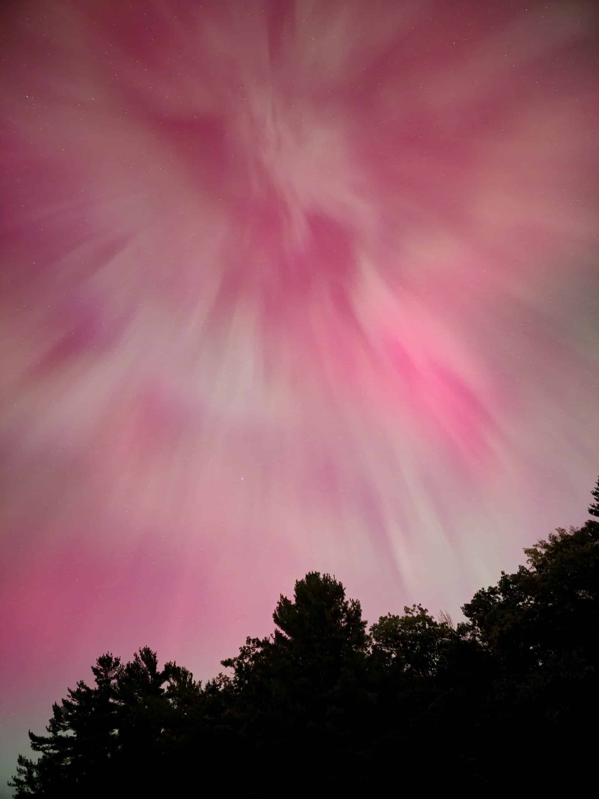 A pink coronal aurora borealis overhead.