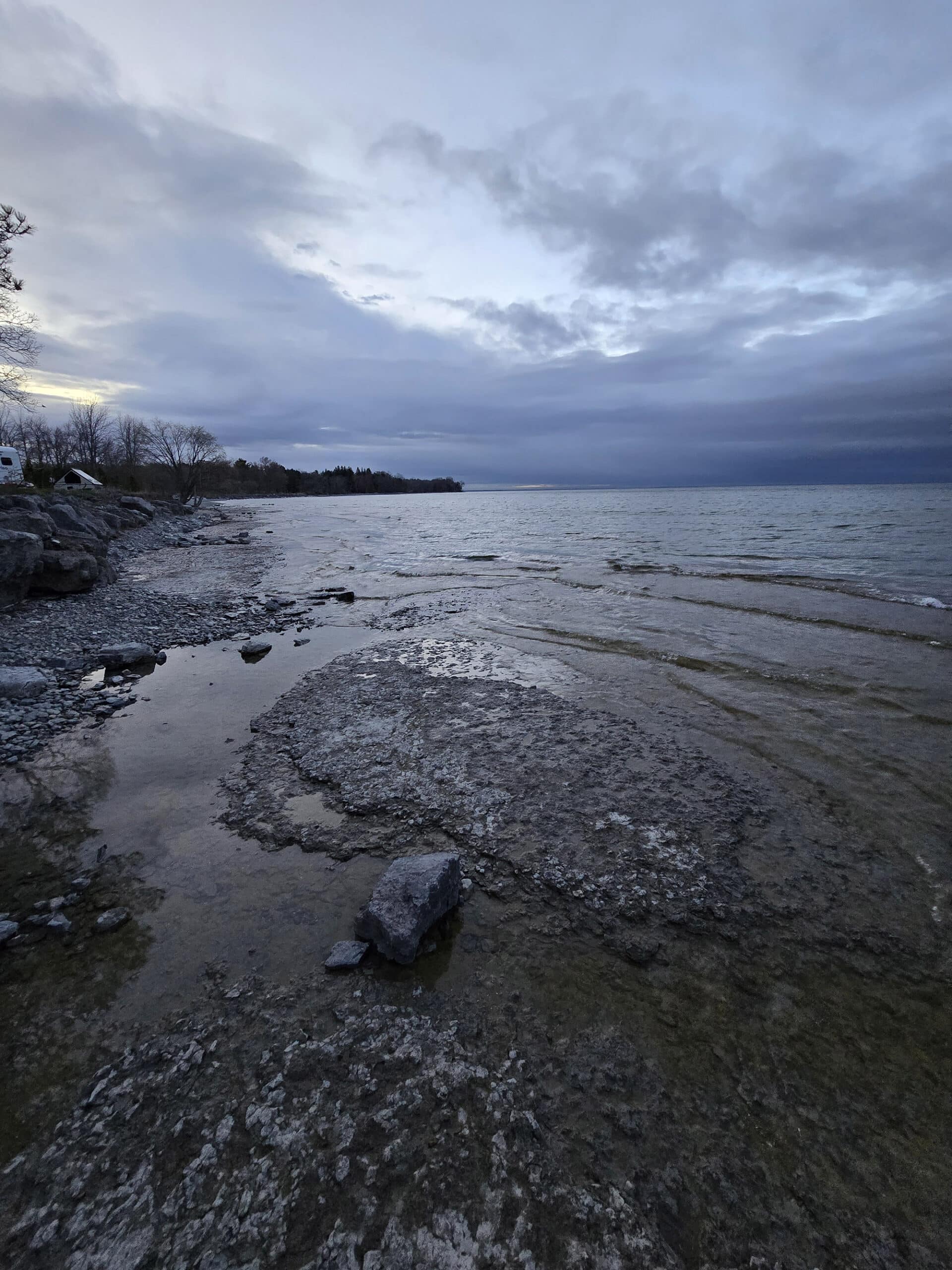 Rocky shoreline of Lake Ontario at dusk.