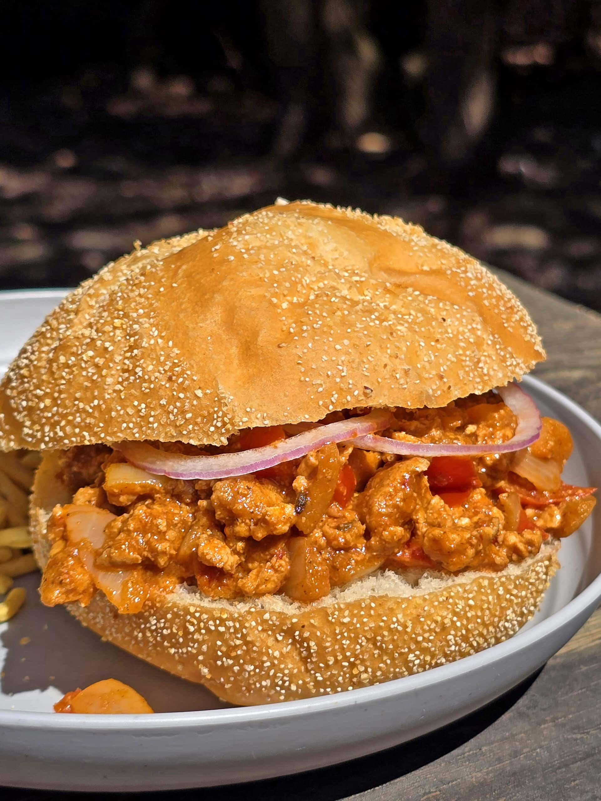 A butter chicken sloppy joes sandwich on a plate.